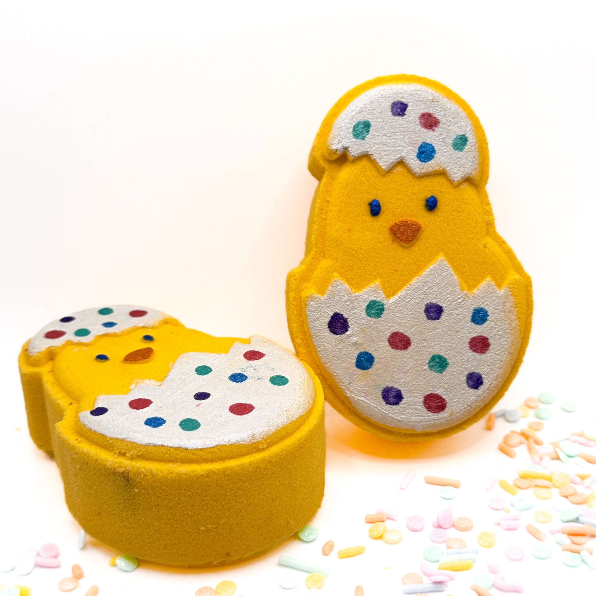 Two chicks in decorated easter egg bath bombs hand painted by Rusted Acre Soap Company.