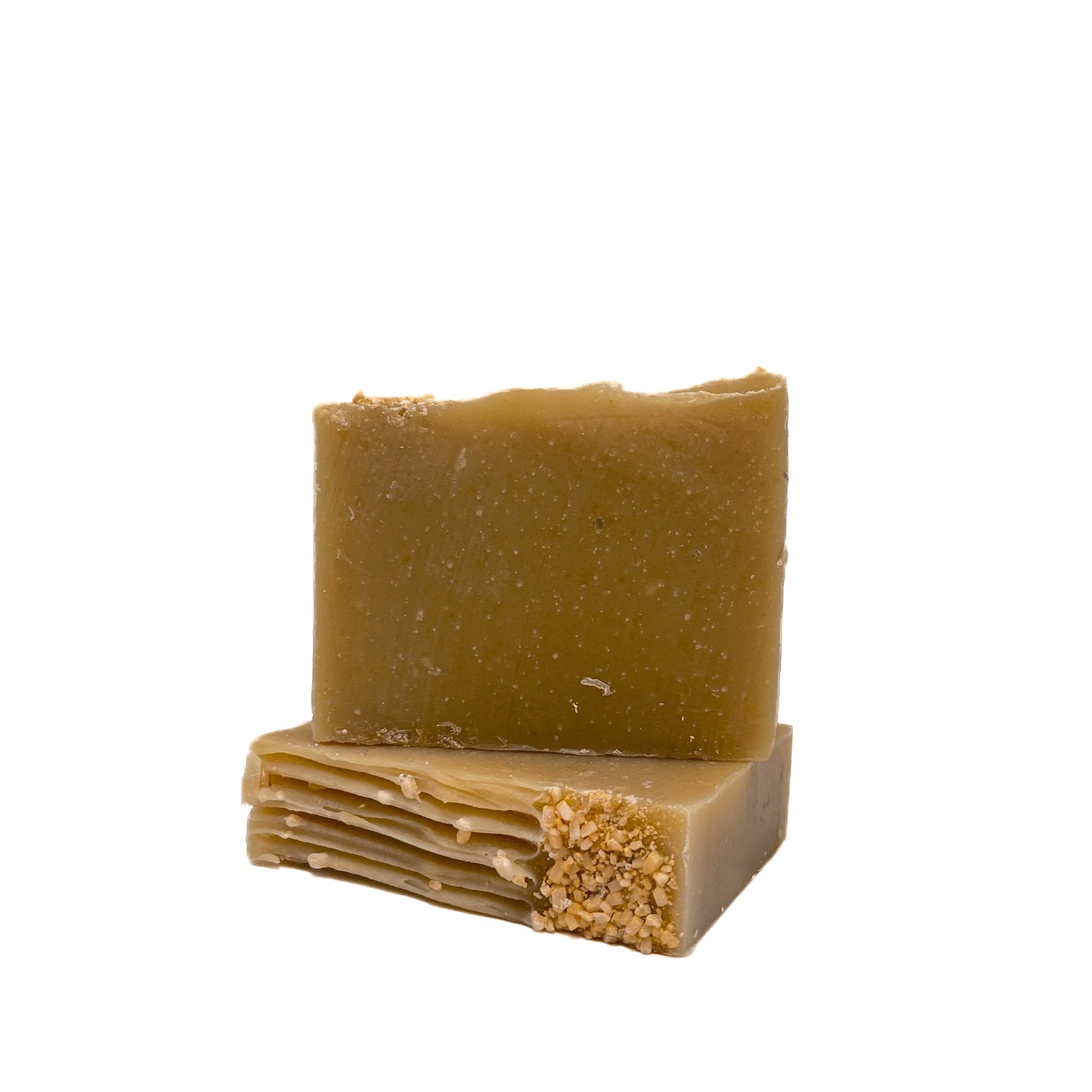Two bars of bamboo colored handmade soap from Rusted Acre Soap Co. One upright one lying flat to show texture.