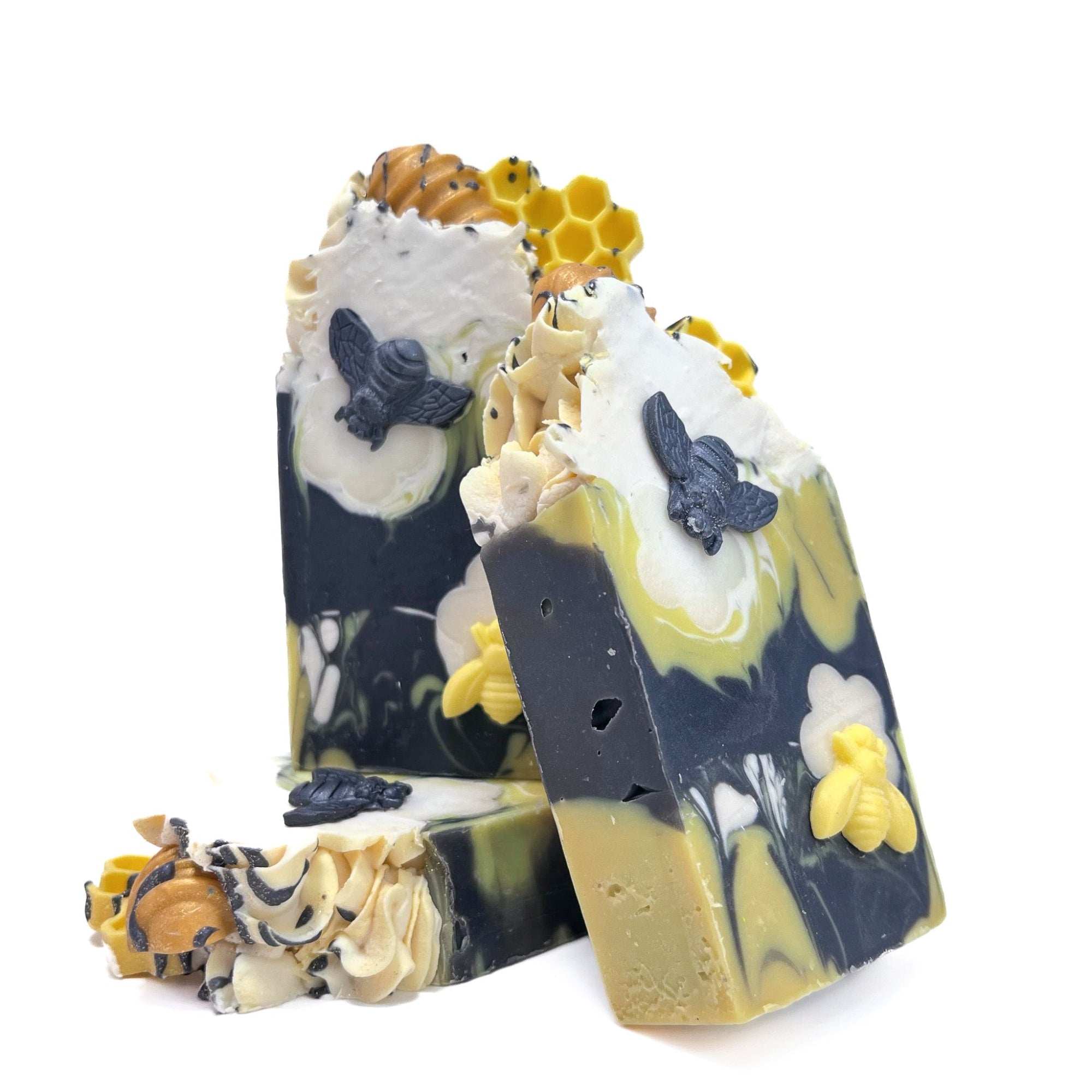 Three bars of Rusted Acre Soap Company's Bee Happy handmade soap. One lying flat, and two standing upright.