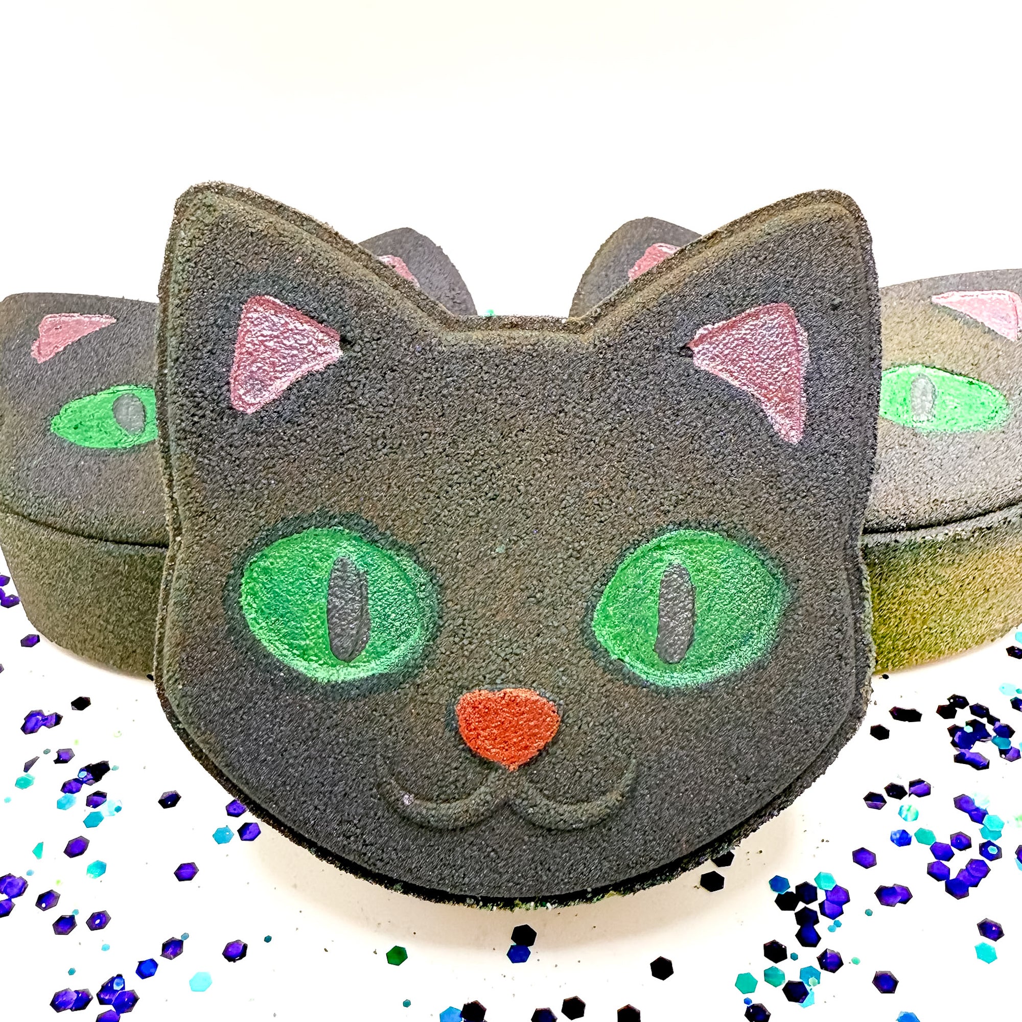 Front-facing Rusted Acre Soap Co. Black Cat Bath Bomb surrounded by more cat-shaped Halloween bath bombs, a fun handmade gift for spooky season.