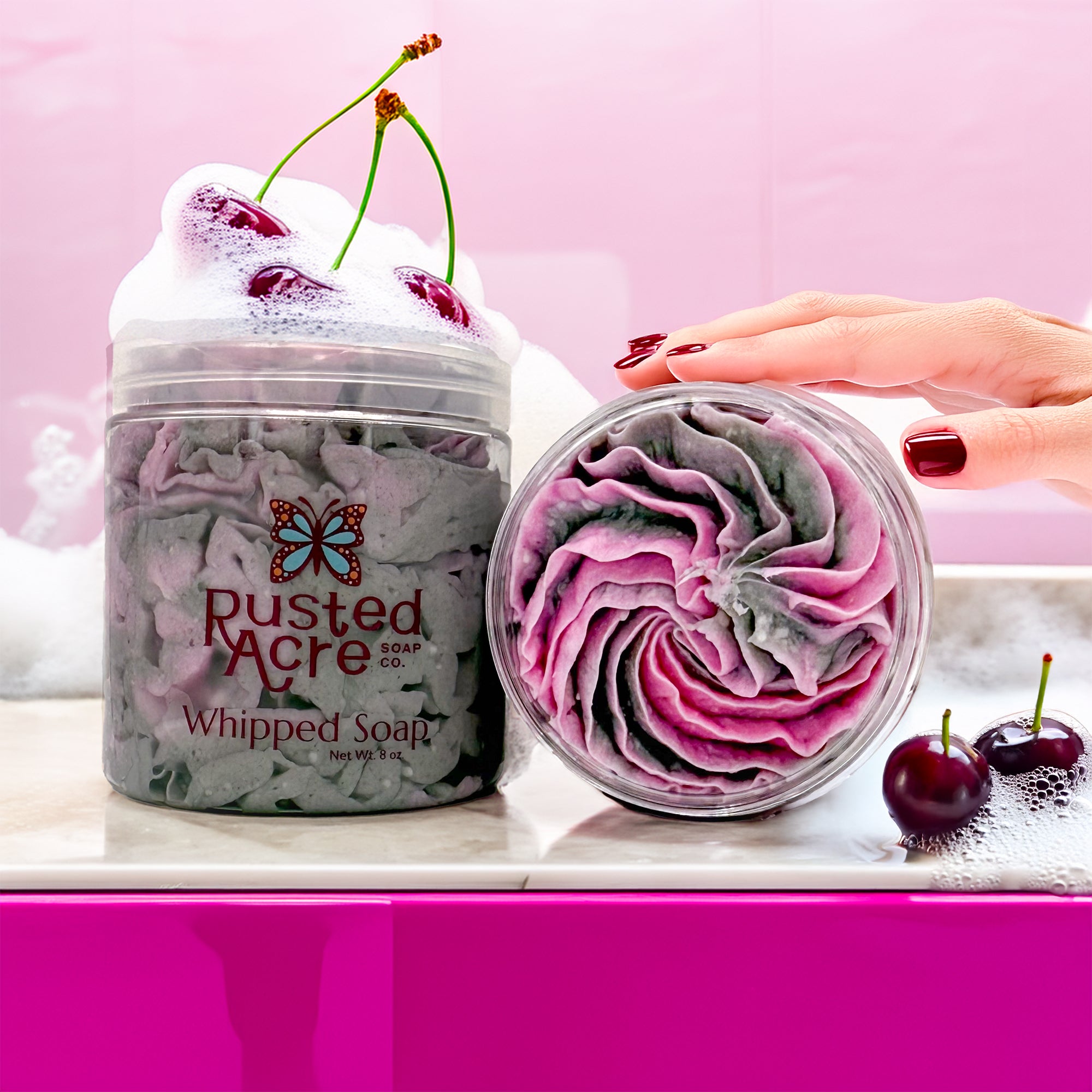 Two jars of Rusted Acre Soap Company's tuxedo whipped soap in a lifestyle image.