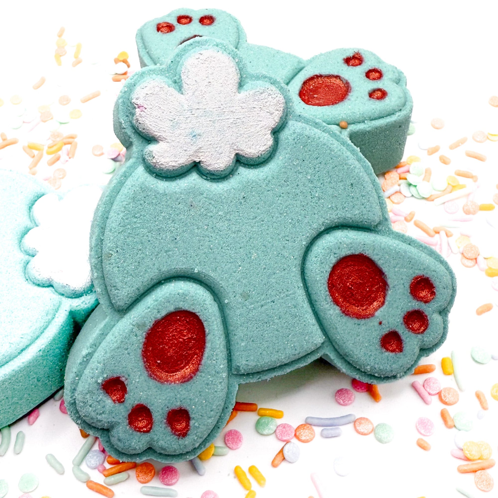 One Teal bunny but bath bomb made by rusted acre soap company with sprinkles scattered around.