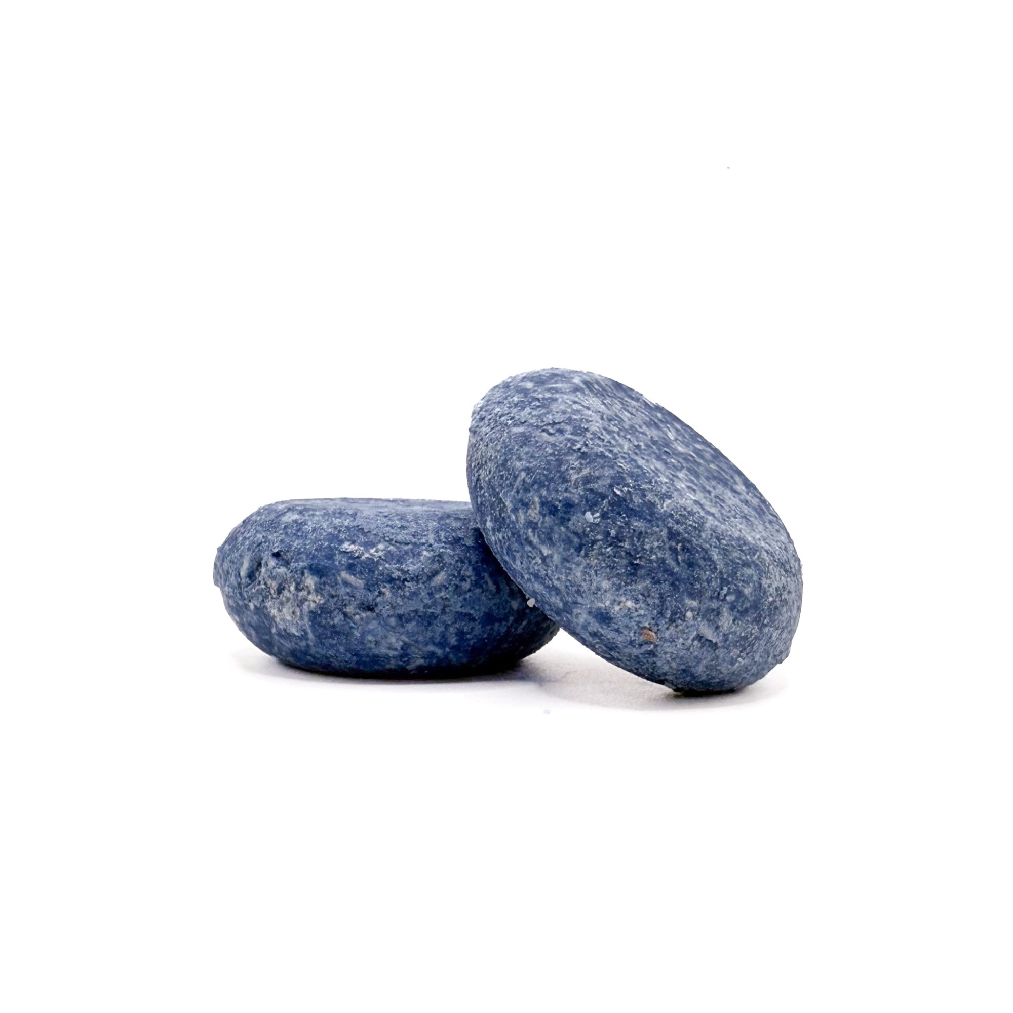 Two blue round solid cabana mens shampoo bars from Rusted Acre Soap Company. One leaning on the other.