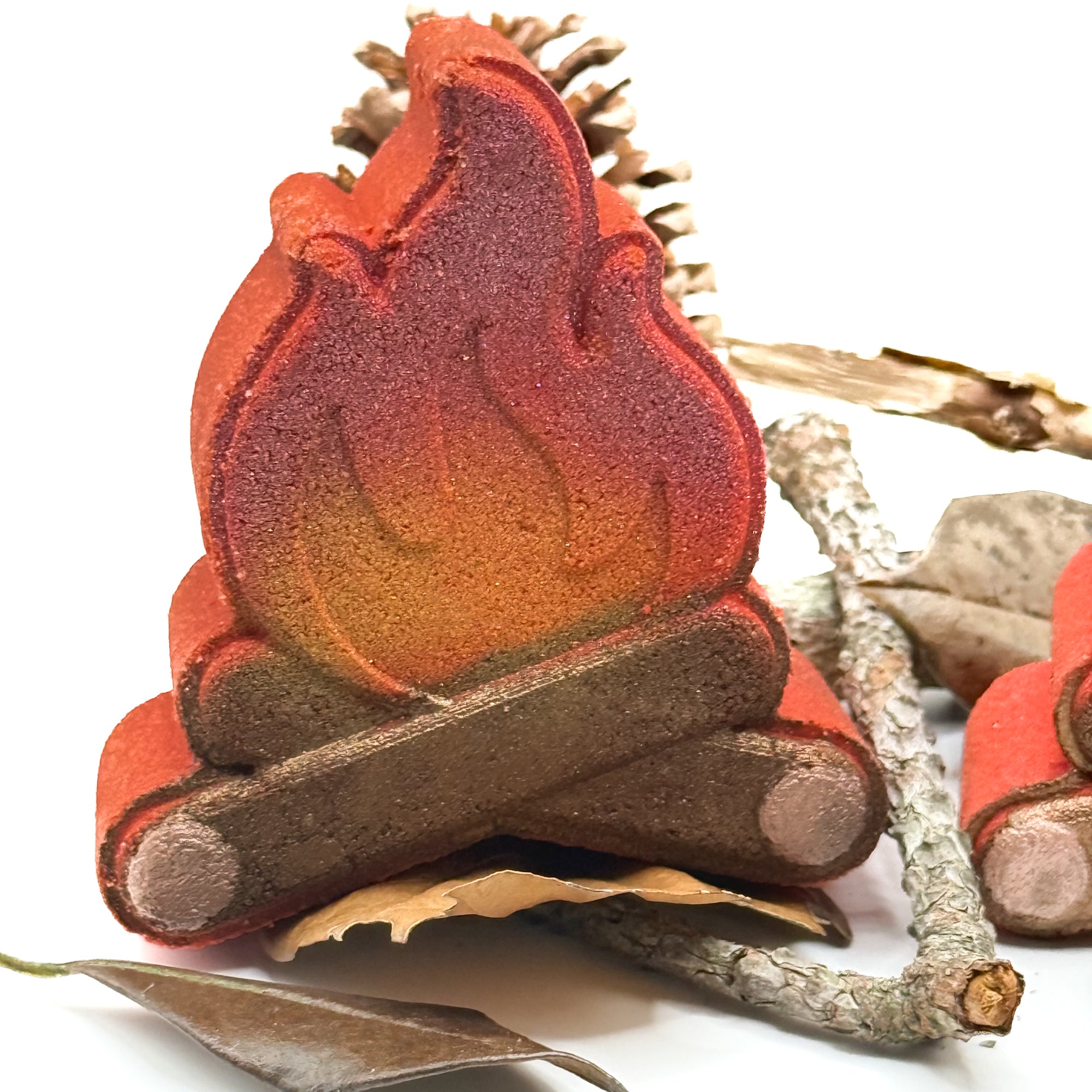 One campfire shaped bath bomb. Hand-painted logs with flames airbrushed orange to red.