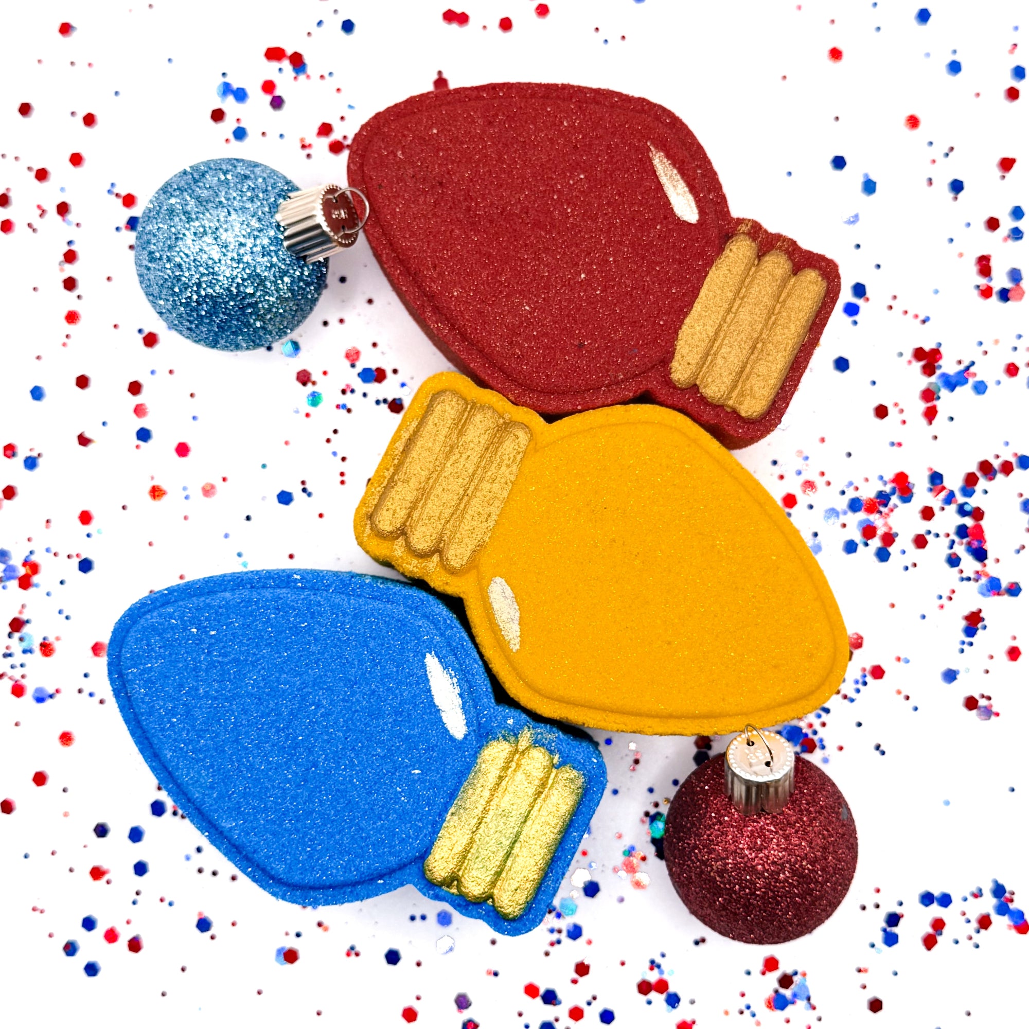 Three Christmas light bath bombs, yellow, red-blue. Hand painted by Rusted Acre Soap Co