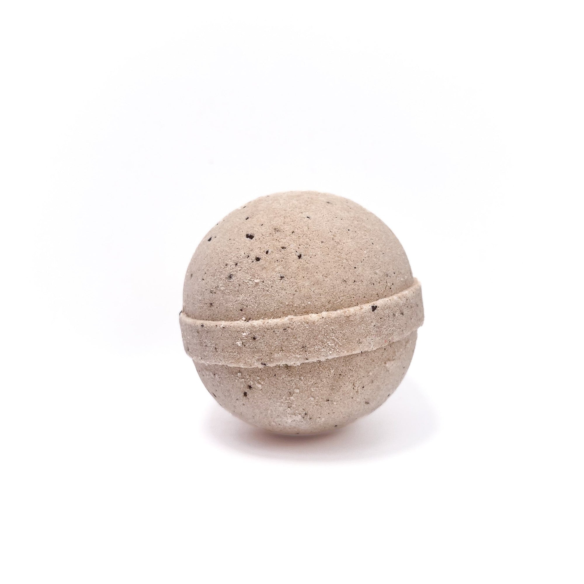 One round coffee bath bomb cream in color with coffee grounds sprinkled in.