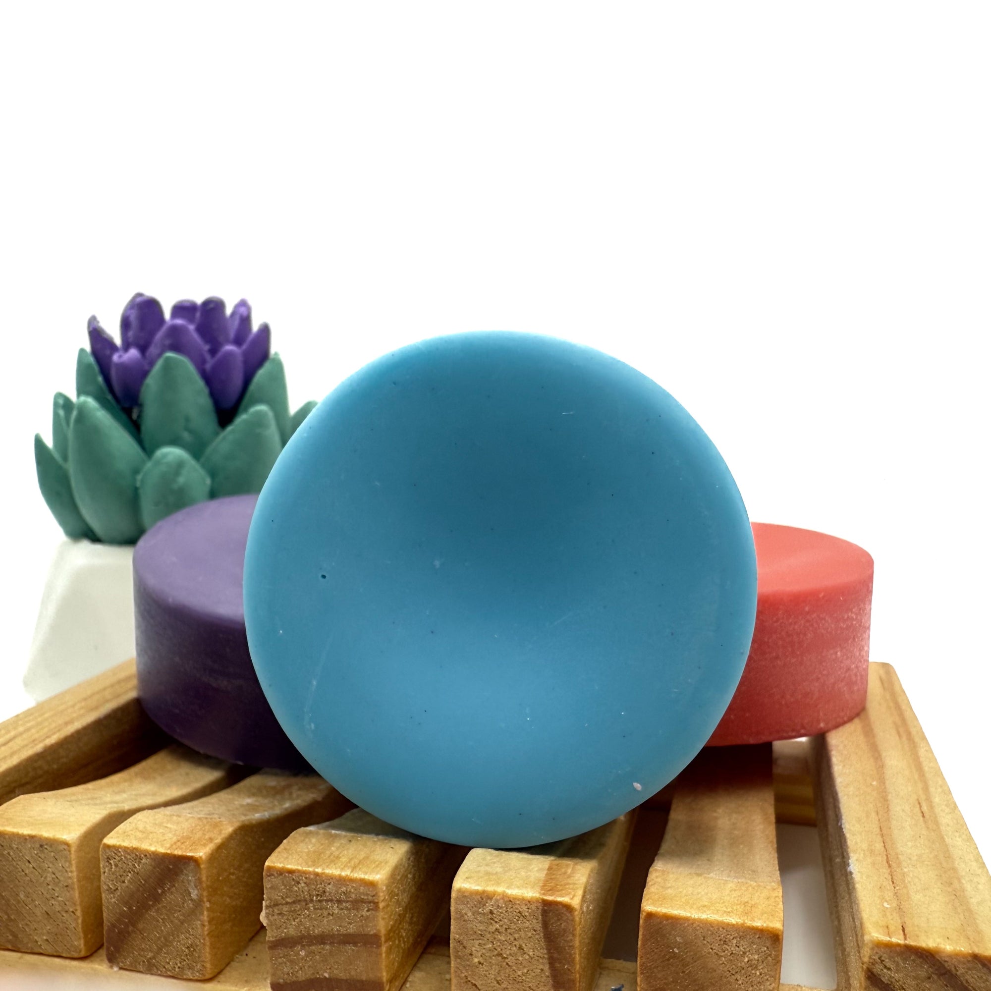 Round blue conditioner bar for hair on wood soap lift.