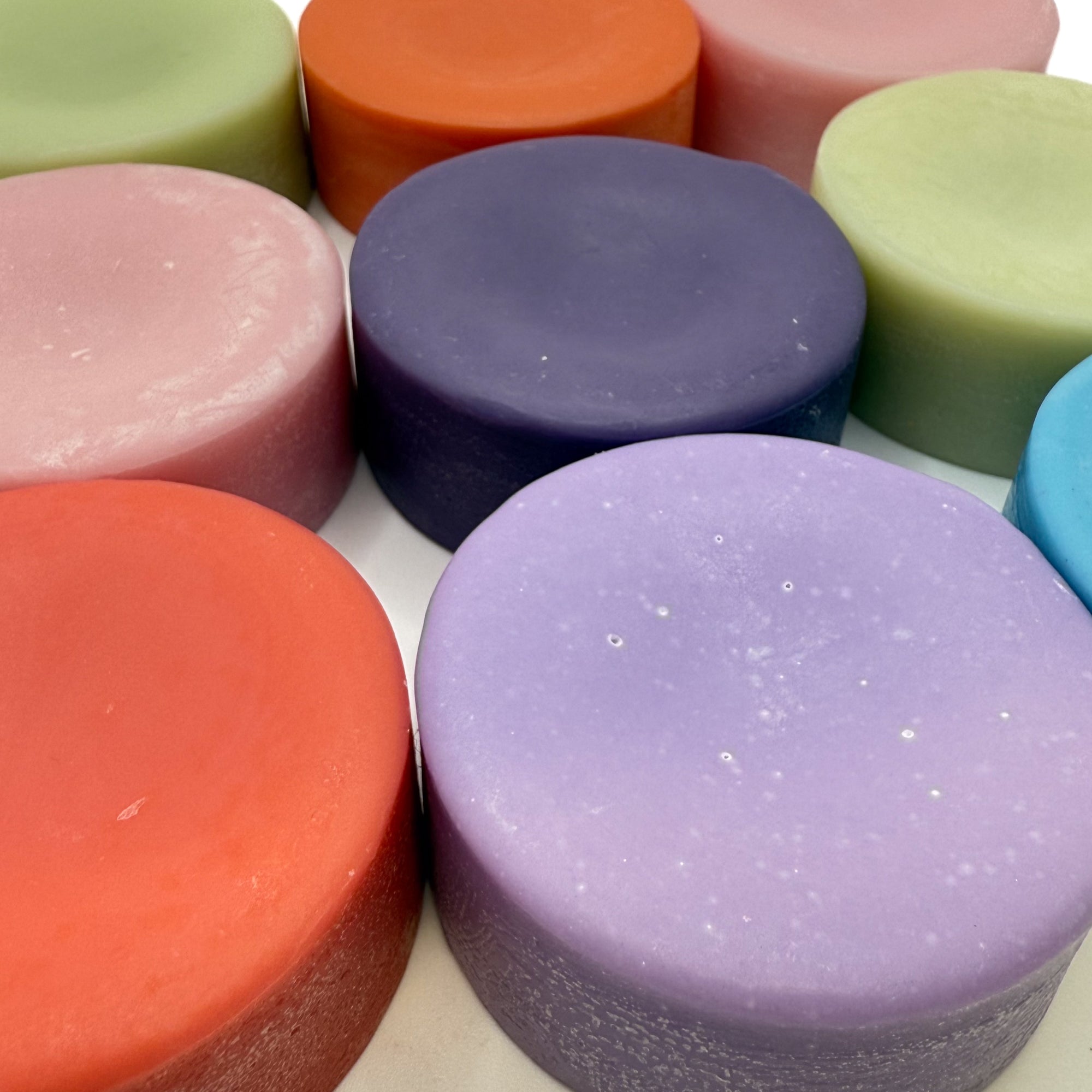 Multi colored conditioner bars laying flat displayed at an angle.