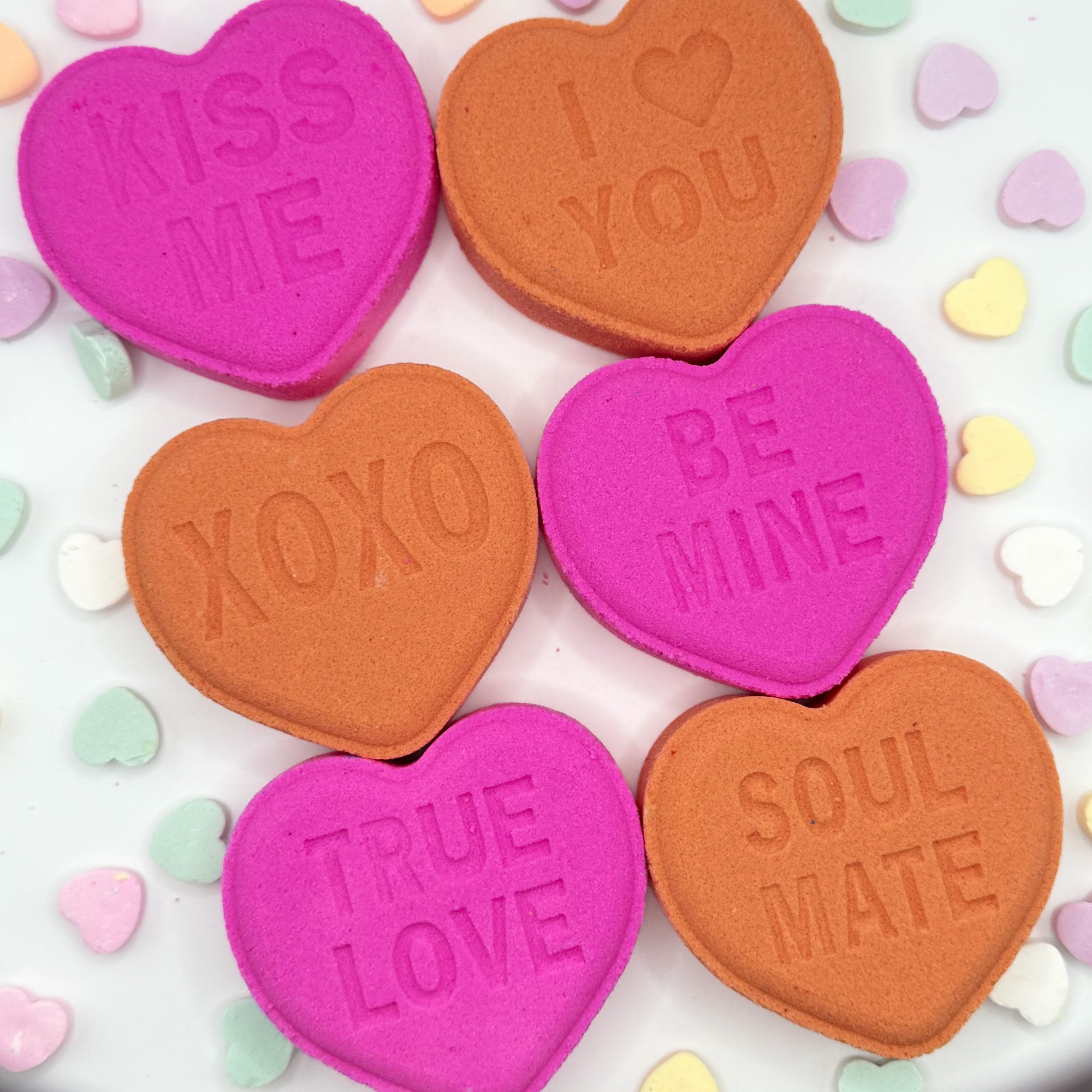 Pink and peach heart shaped bath bombs with Valentines text on a white background.