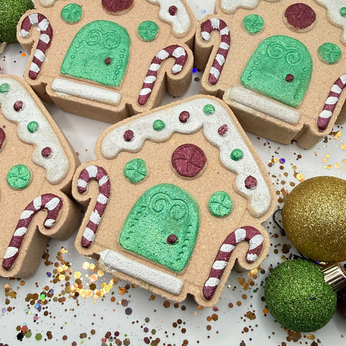 Hand painted gingerbread house with Christmas decorations surrounding it.