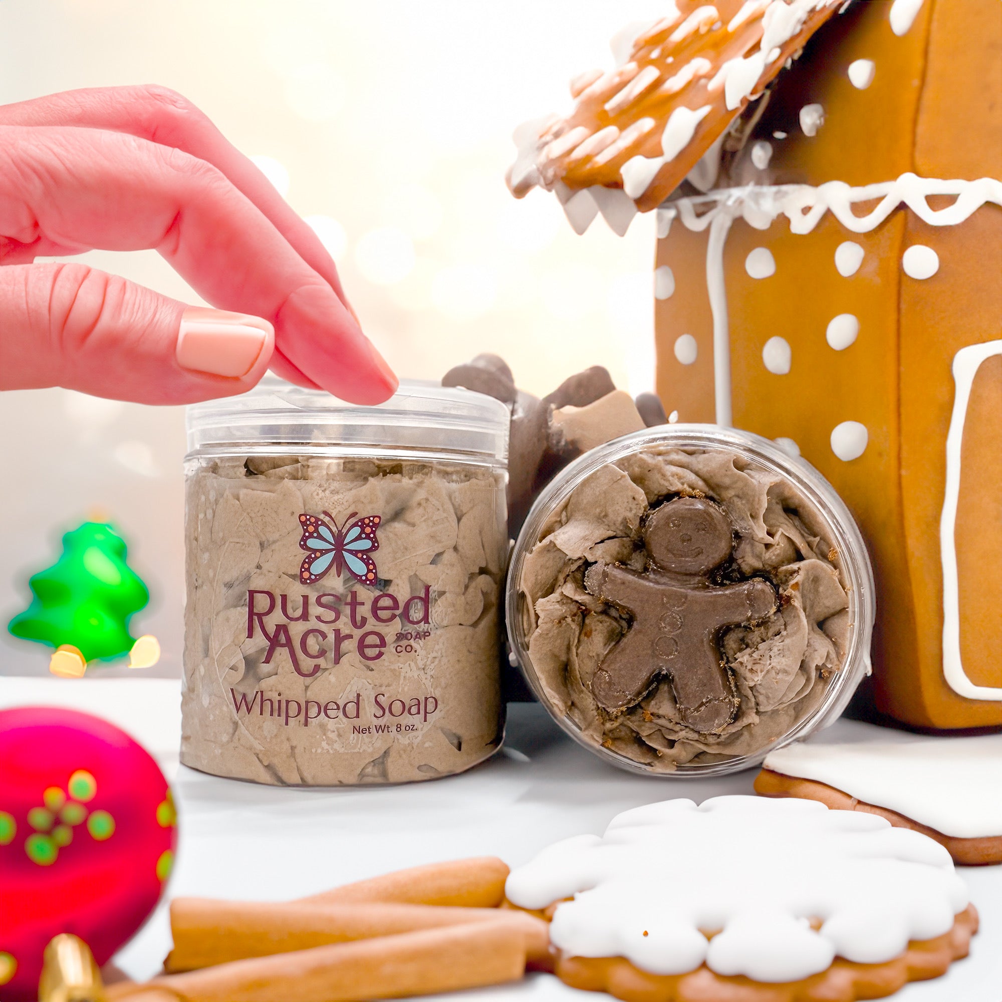 Two jars of Rusted Acre Soap Company’s gingerbread whipped soap front and top view in a lifestyle setting.