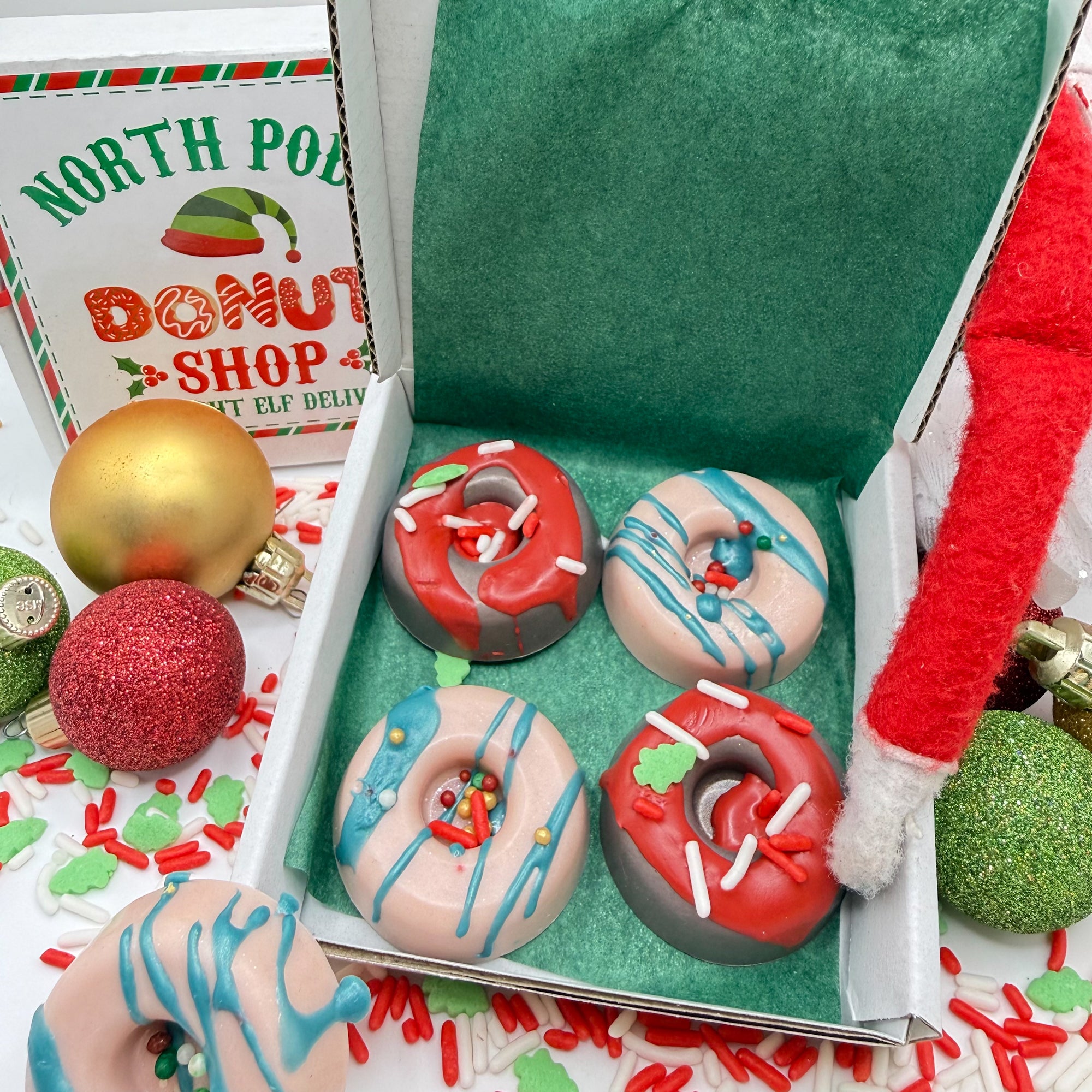 Decorative handmade mini donut soaps in a box with North Pole donut shop themed packaging.