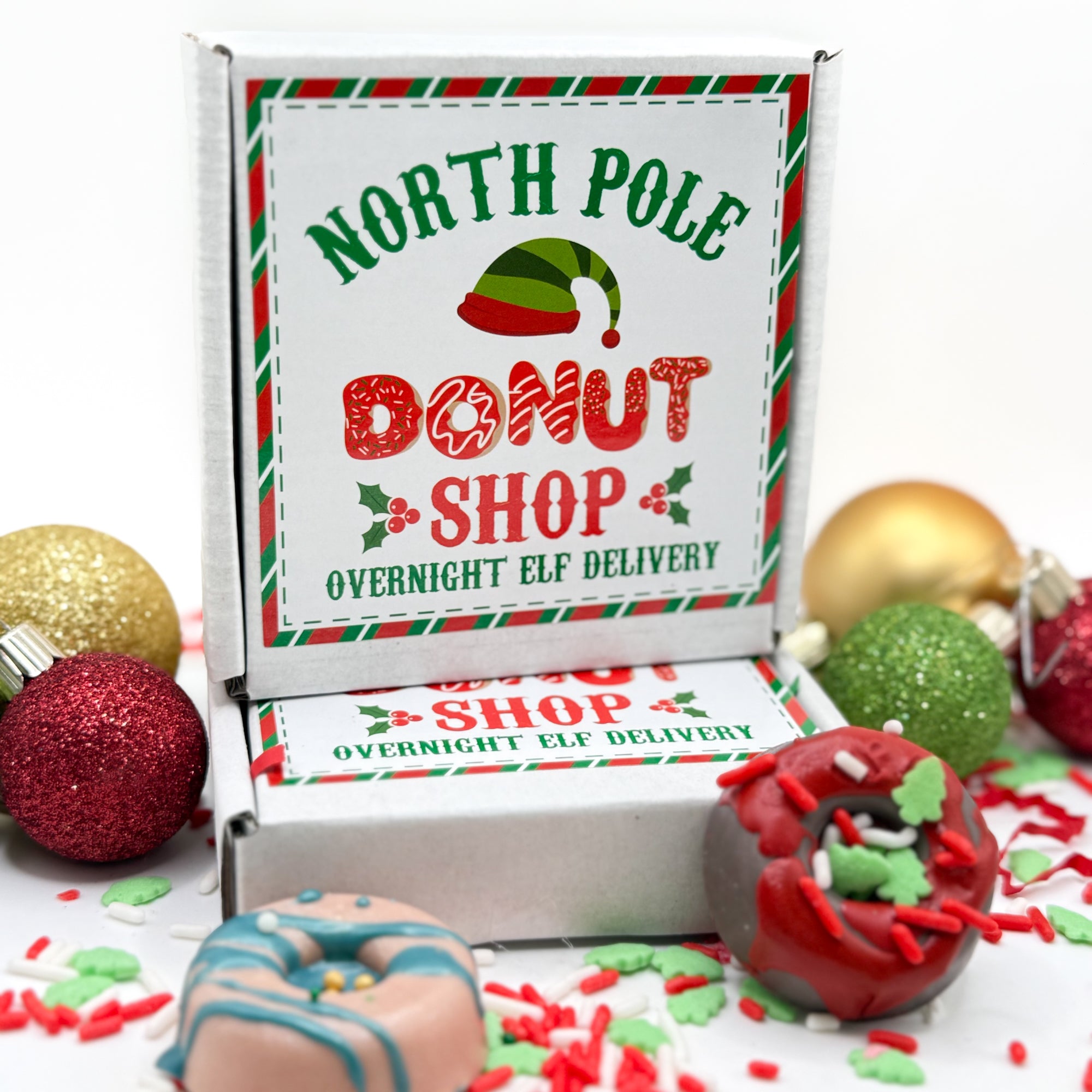 Donut shop box with min soap donuts and Christmas ornaments on a white background.