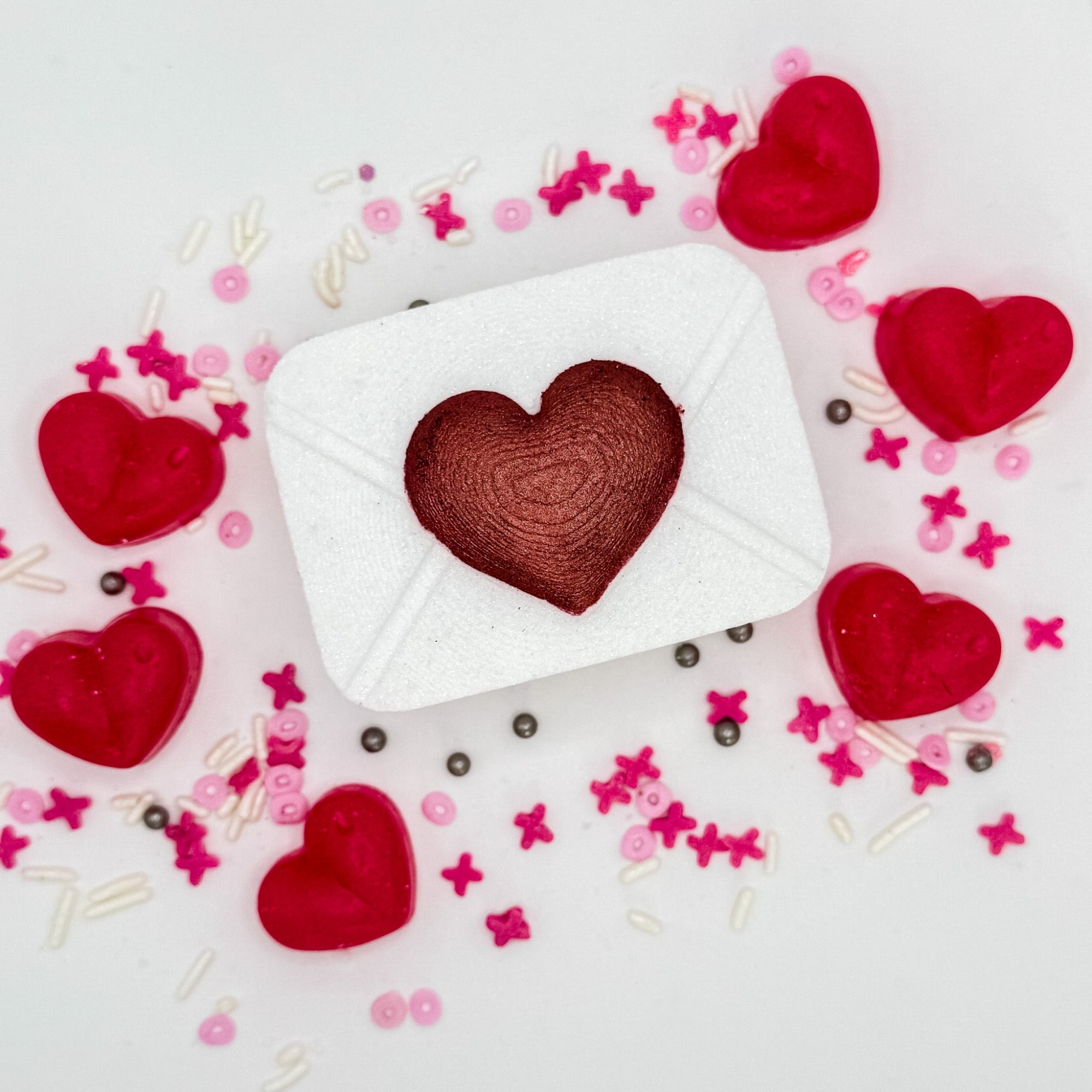 Pink love letter bath bomb with hand-painted raised red heart on the front.