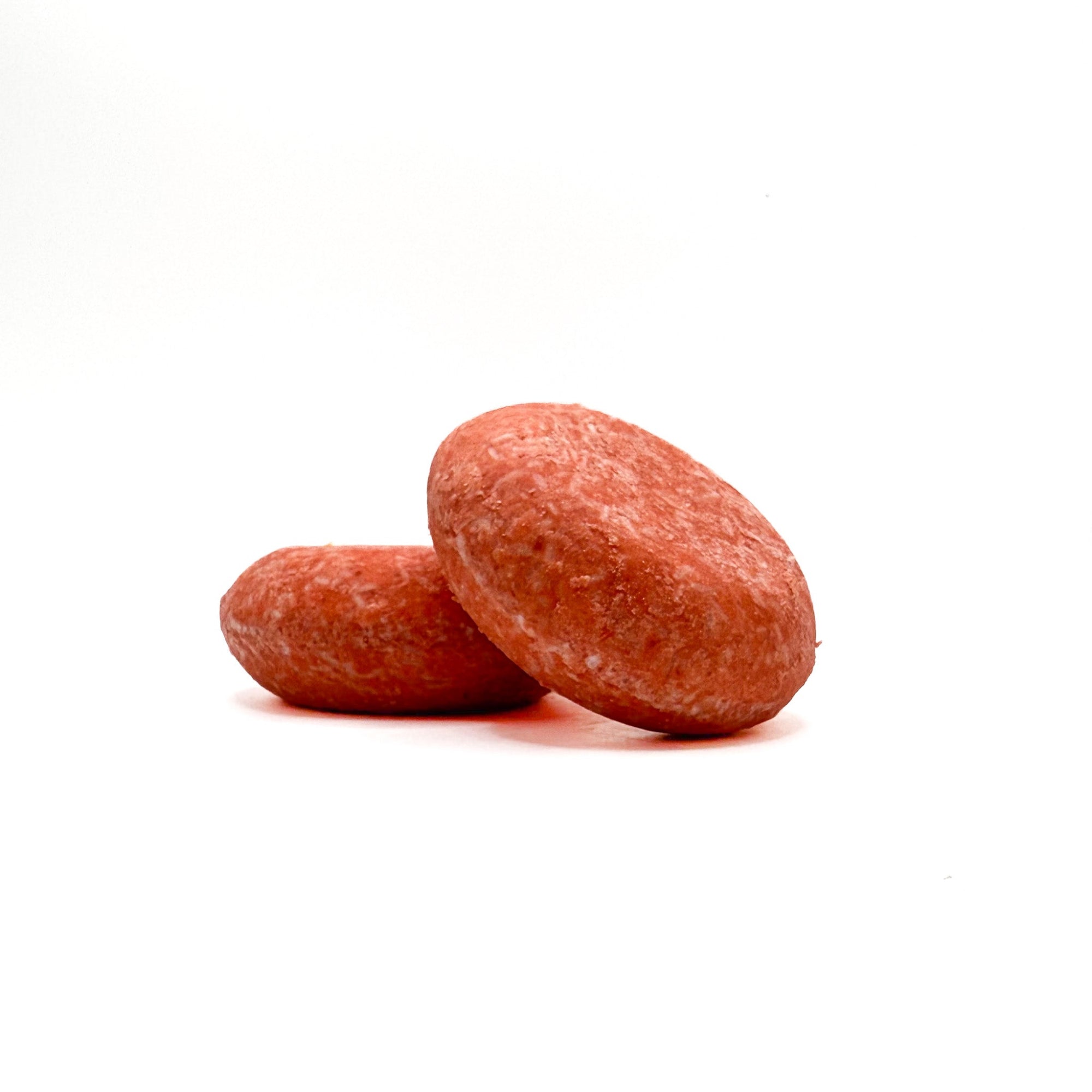 Two orange zero waste shampoo bars in mango tango scent from Rusted Acre Soap Company.