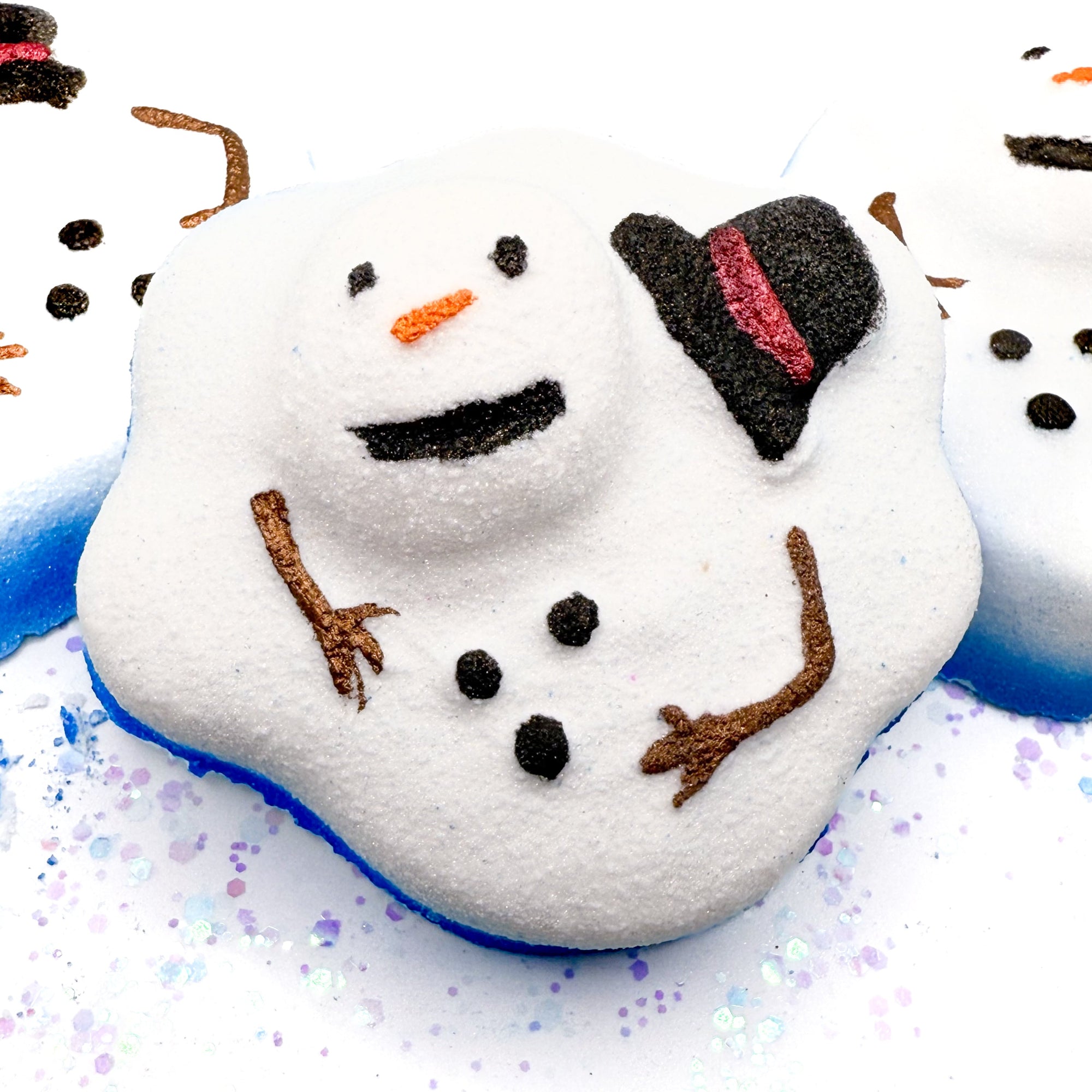 Melting snowman bath bomb with a blue base on a white background