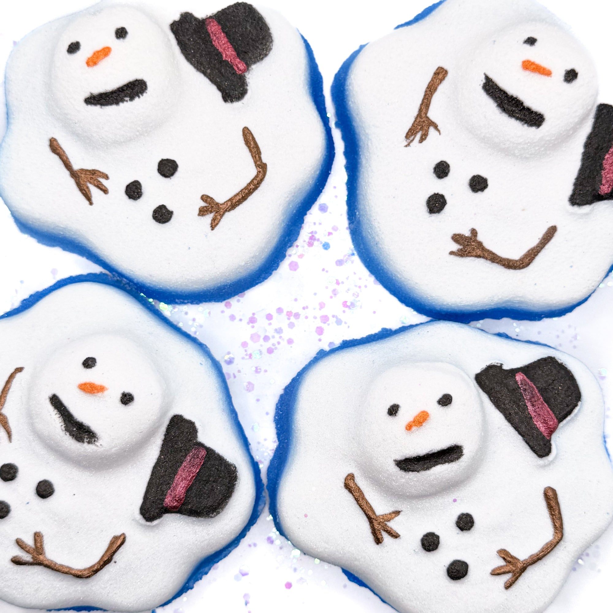 Four melting snowman shaped bath bombs with blue frosted shimmer on a white background