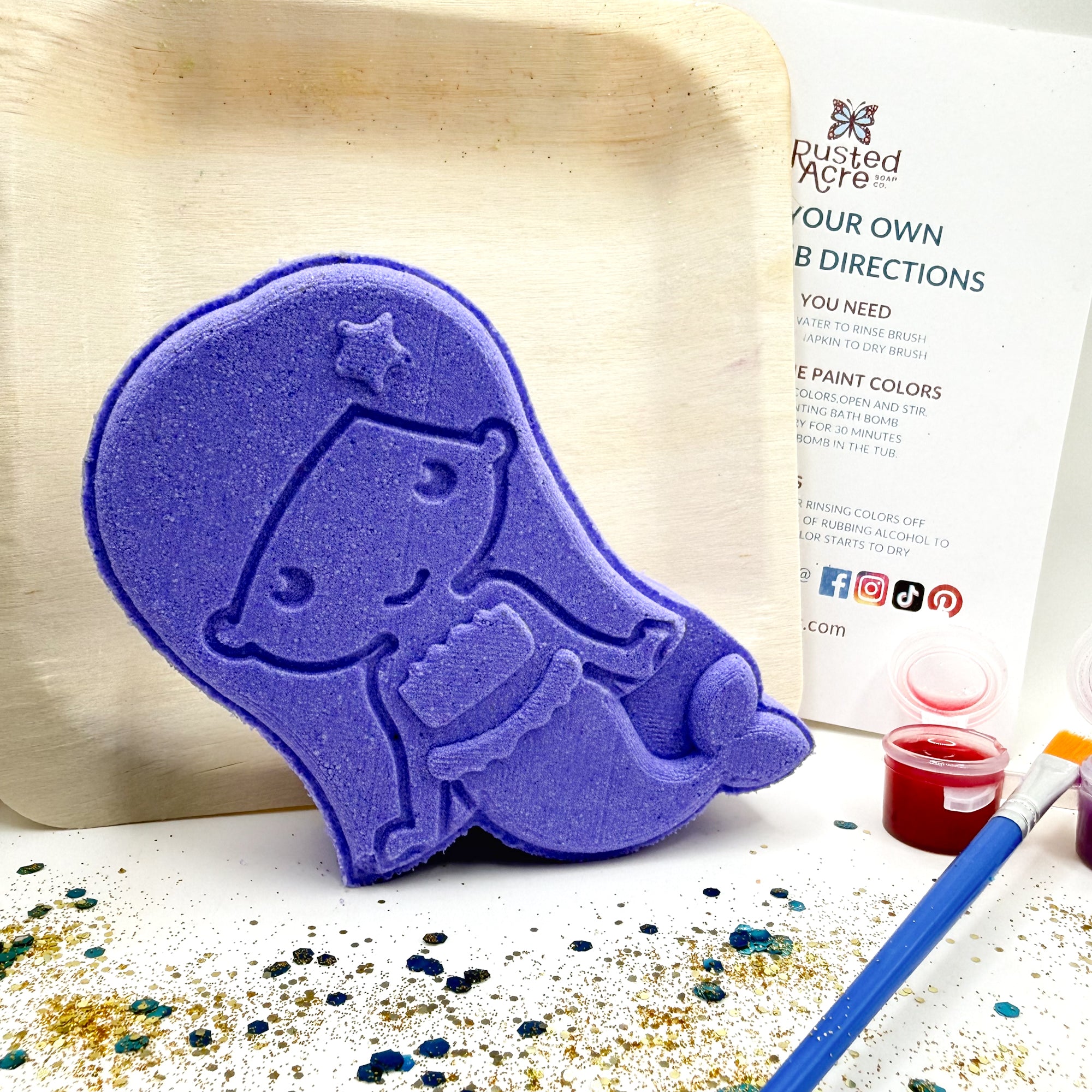 Mermaid, paint your own bath bomb kit. It comes as a blank white bath bomb canvas along with 3 random colors in pot, paint brush, witch hazel, and instructions.