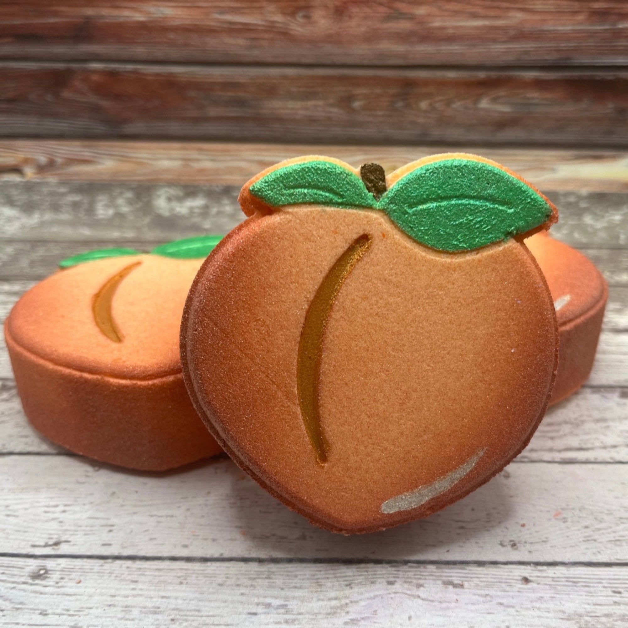 Hand painted peach bath bomb on Rustic wood background. Made by Rusted Acre Soap Co.