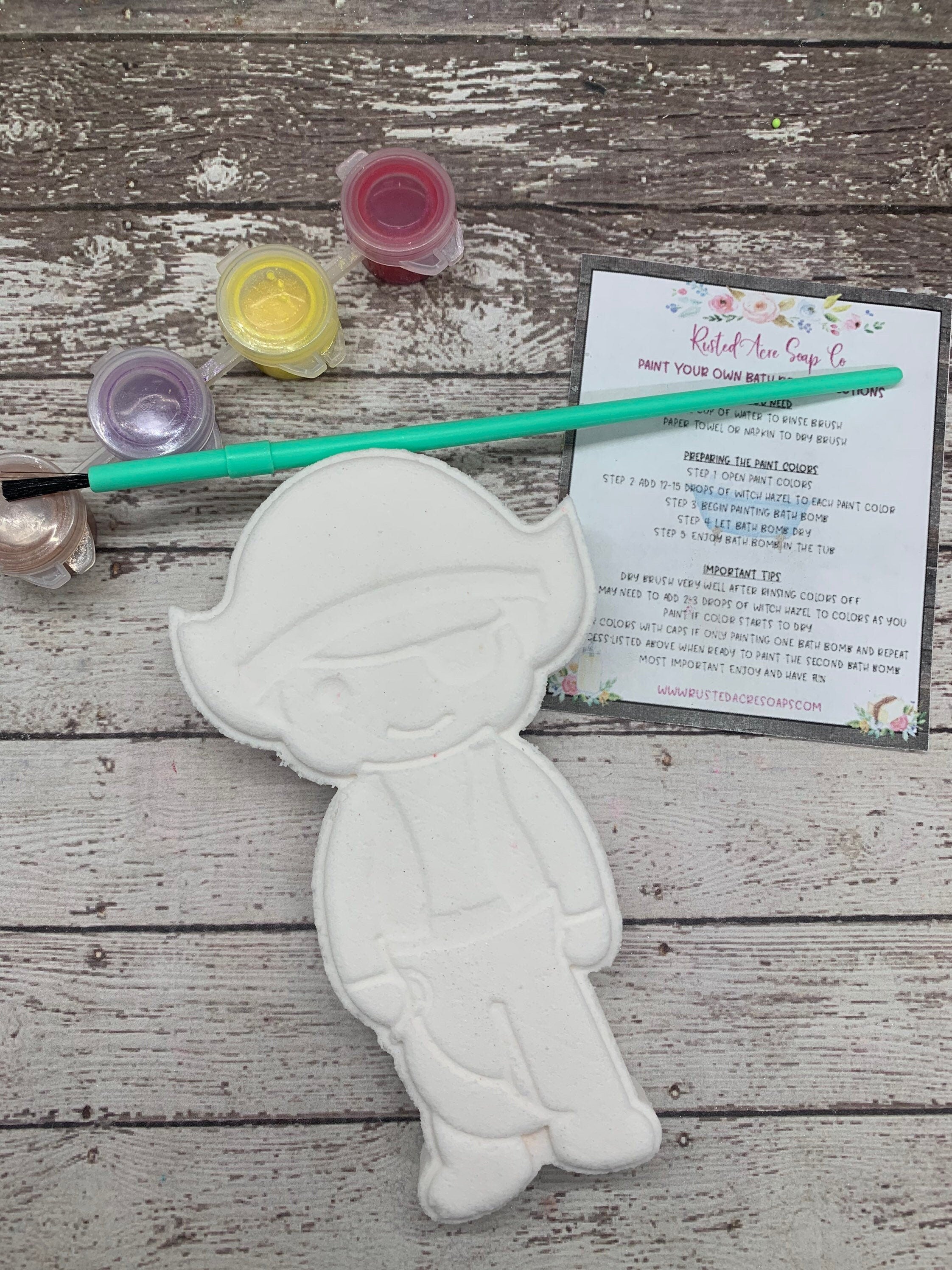 Pirate, paint your own bath bomb kit. It comes as a blank white bath bomb canvas along with 3 random colors in pot, paint brush, witch hazel, and instructions.
