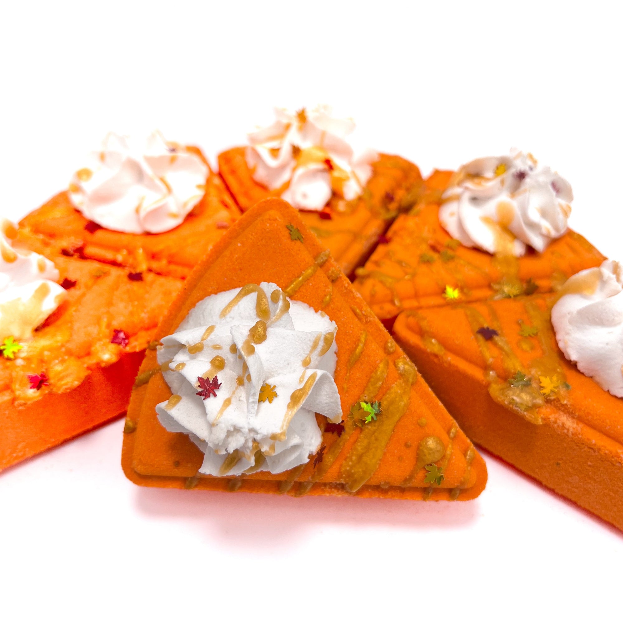 Pumpkin Pie bath bombs with whipped bubble bath frosting on a white background.
