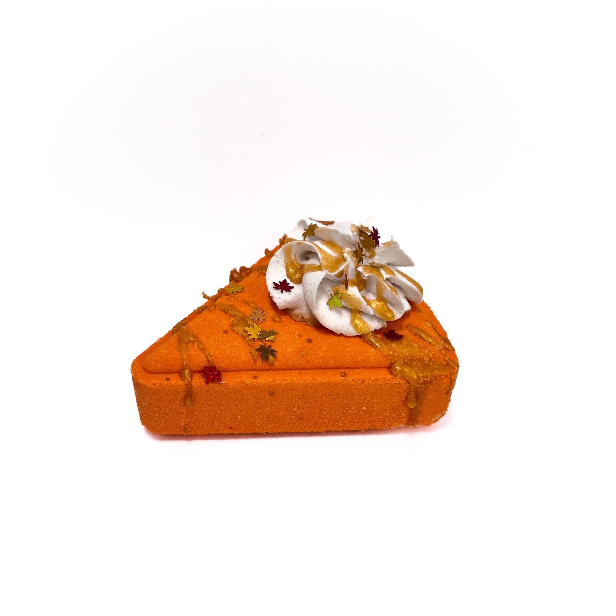 An orange bath bomb shaped like a slice of pumpkin pie. Topped with a puff of cream colored bubble frosting.