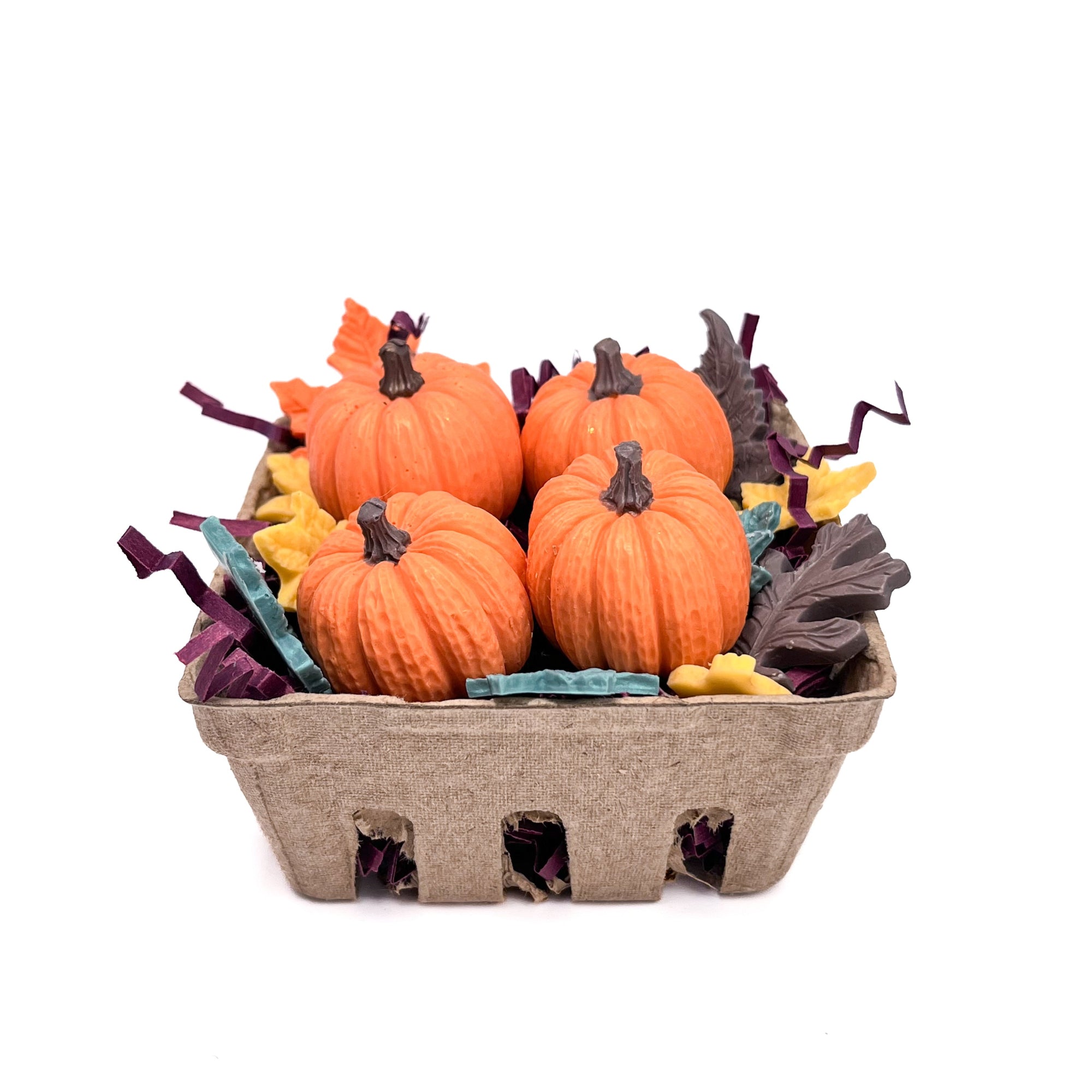 Carton of four orange pumpkin soaps with decorative leaves on a white background