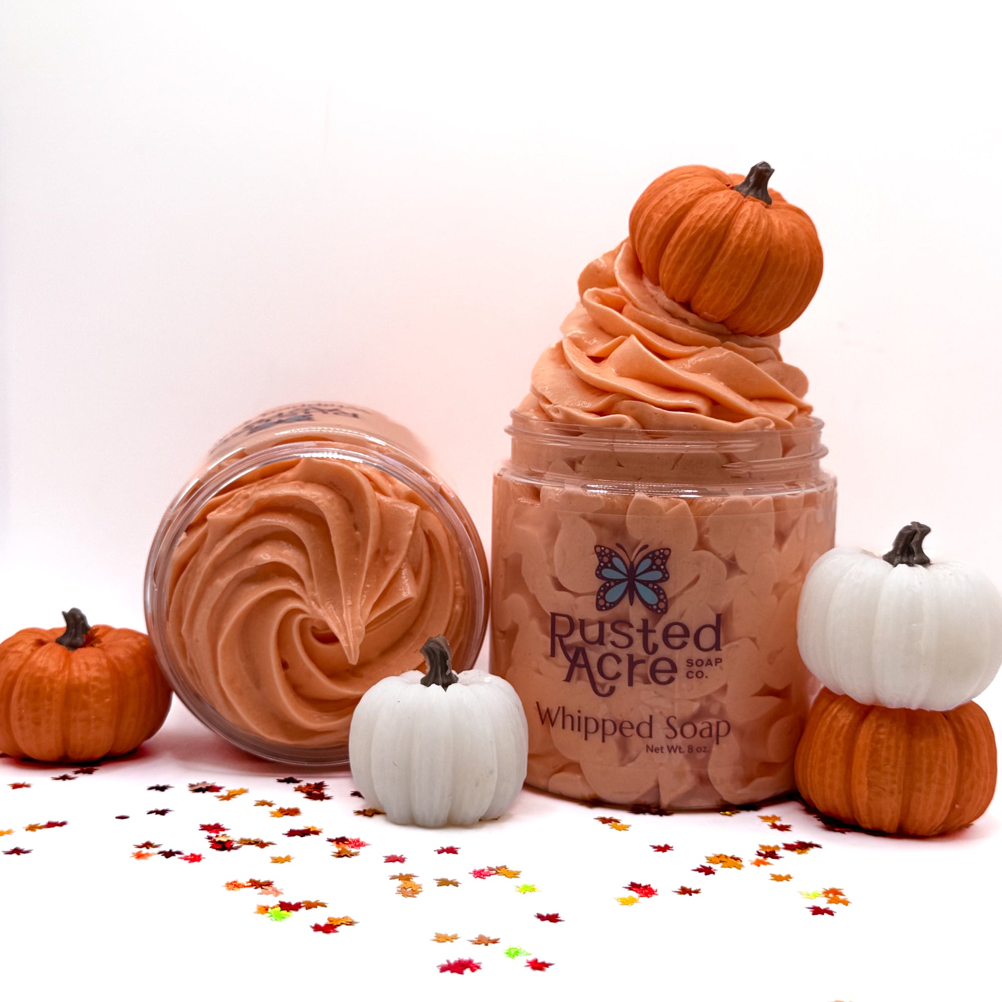 Two jars of Rusted Acre Soap Co Pumpkin spice whipped soap with pumpkins and fall leaves on a white background.