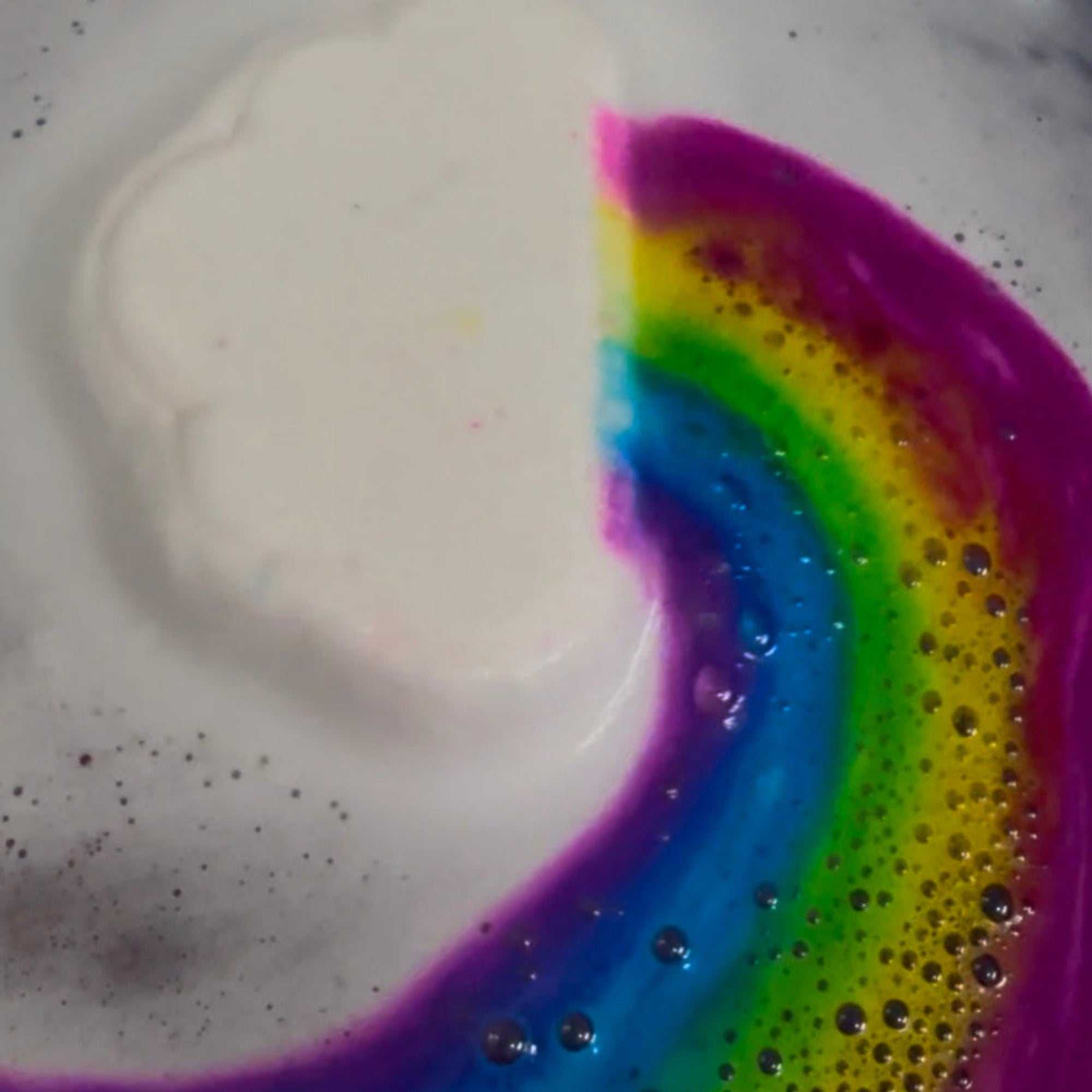 Rusted Acre Soap Companies Rainbow Cloud bath bomb putting on a color show.