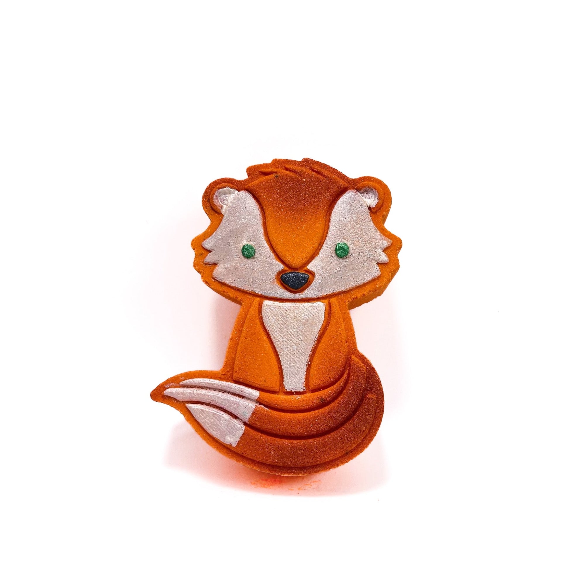 A orange fox shaped bath bomb hand-painted white face, chest, and tail tip. Green eyes, black nose, airbrush highlights.