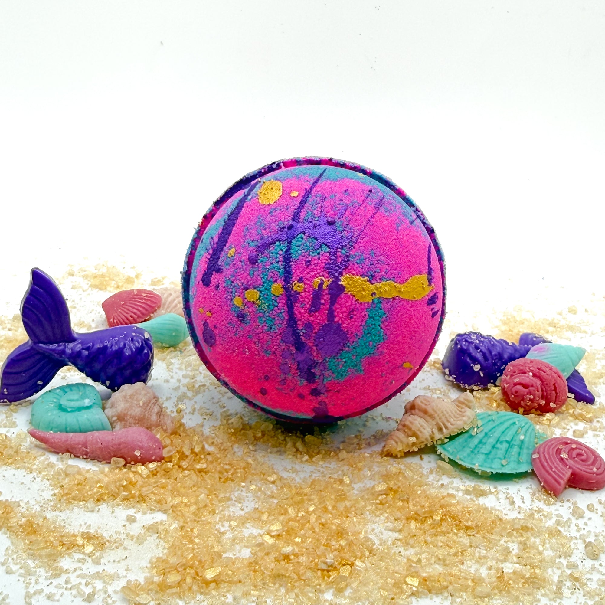 Round bath bomb swirled with with and teal. Splattered with purple and gold mica
