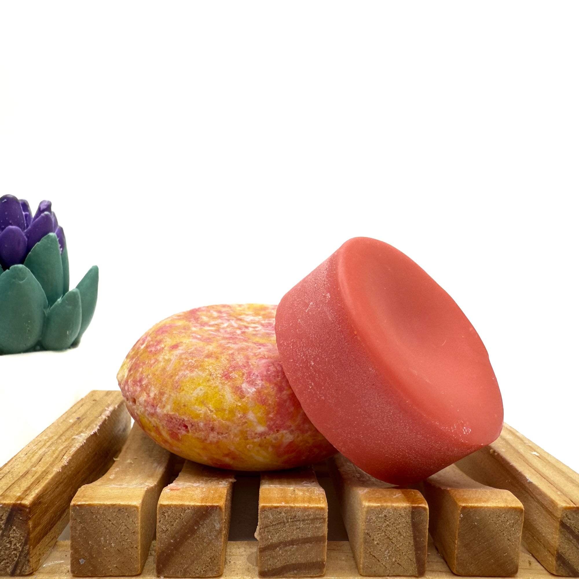Yellow and pink Island Hibiscus zero waste Shampoo and Conditioner bar on a wood soap dish with a white background.