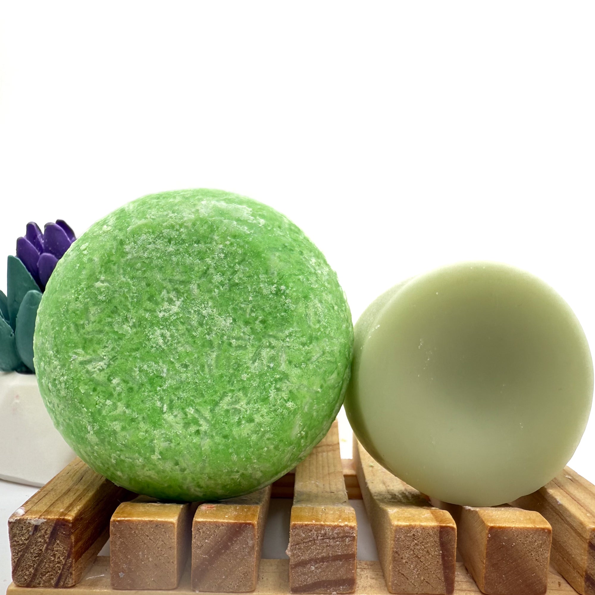 Green summer melon zero waste Shampoo and Conditioner bar on a wood soap dish with a white background standing on side.