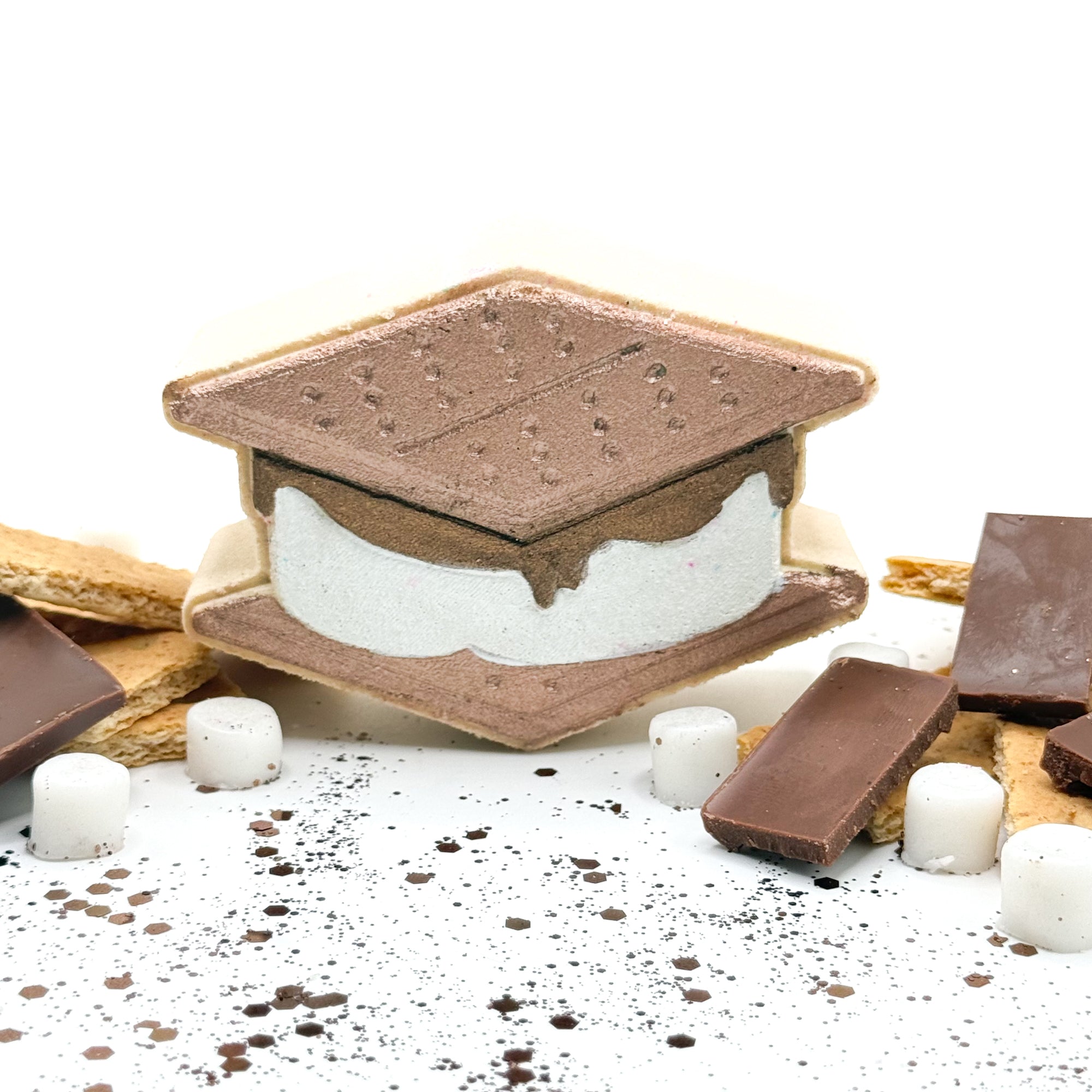 a s'mores shaped bath bomb hand-painted graham crackers, marshmallow, and chocolate bar.