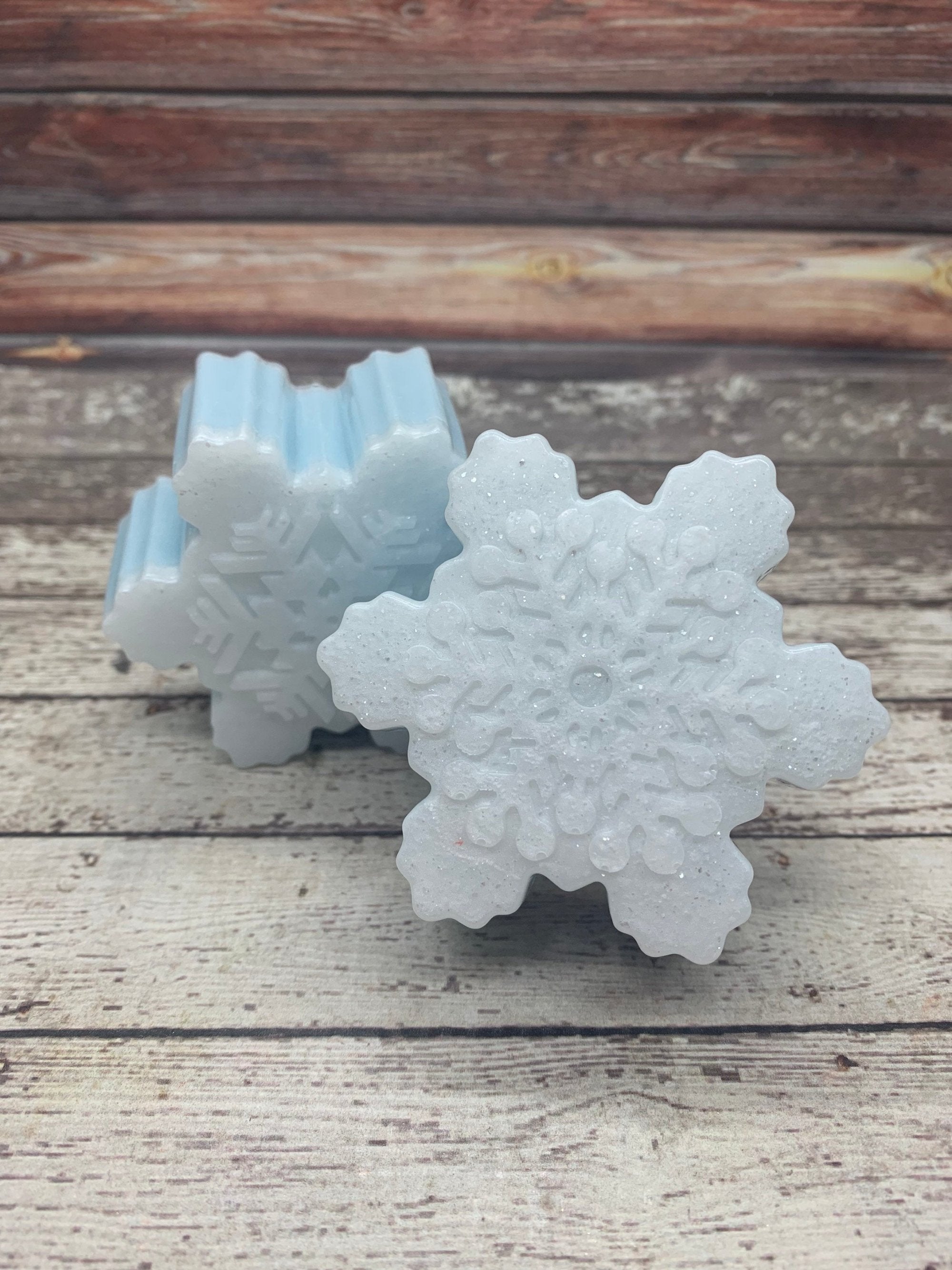 Two snowflake shaped snowflakes. Light blueish-white.