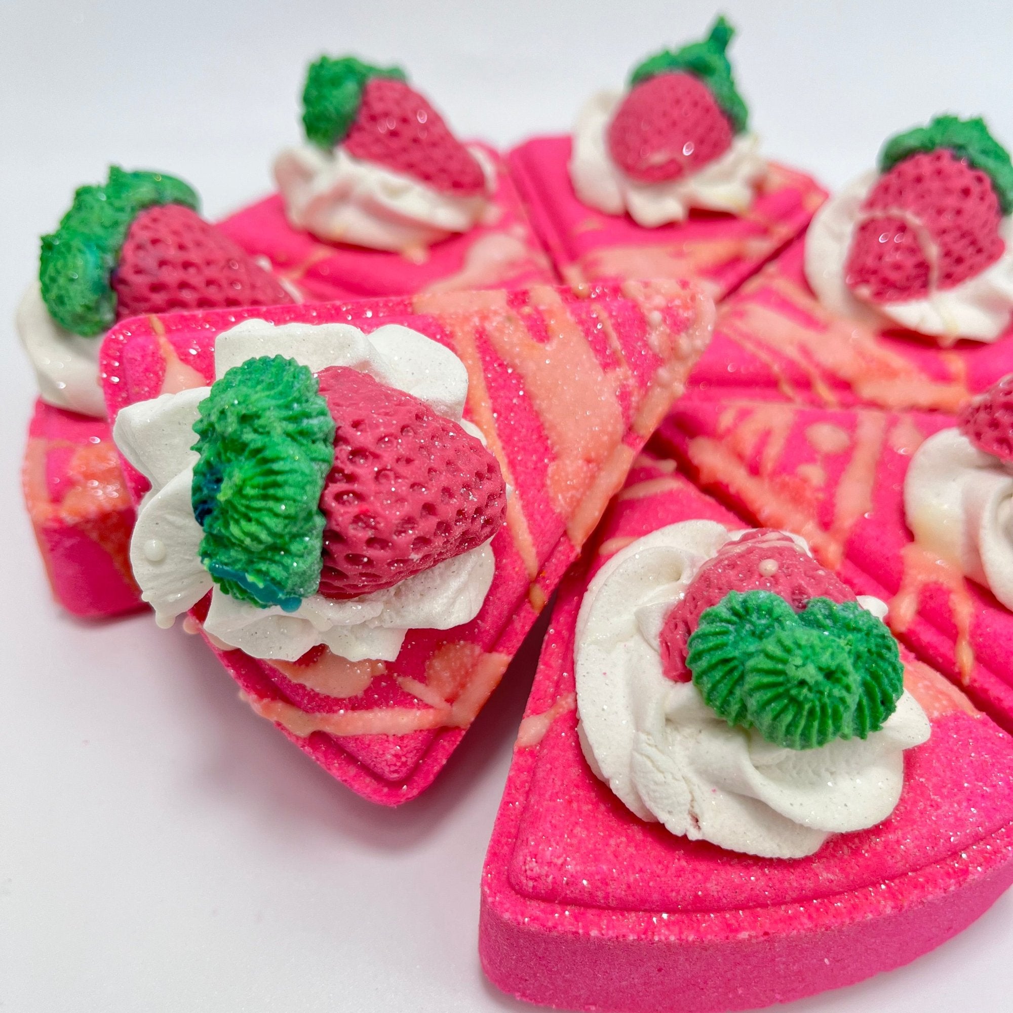 Several slices of pink strawberry bath bombs arranged in a semi-circle.