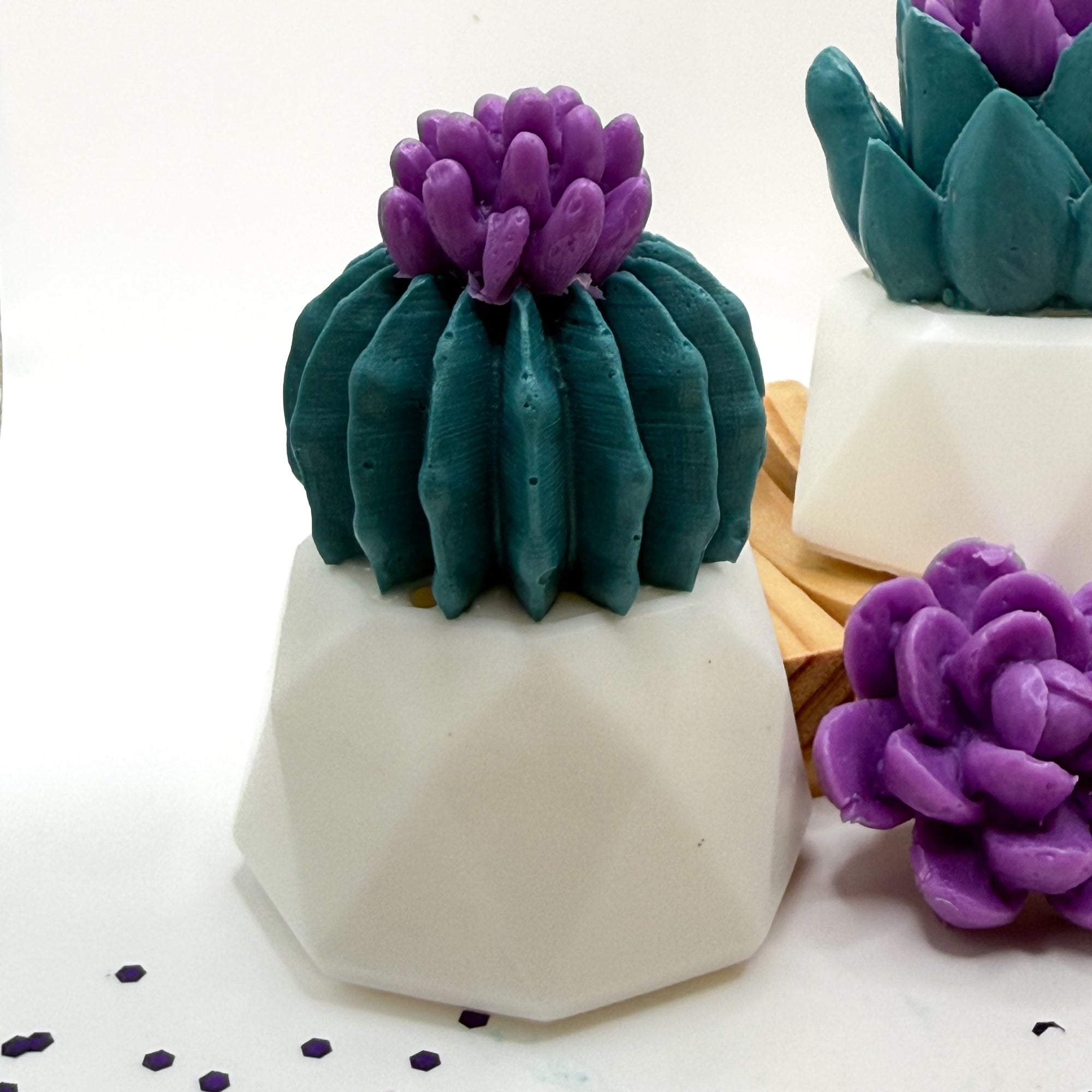 Decorative soap shaped like a succulent cactus with purple flower with a white pot on a white background handmade by Rusted Acre Soap Co.