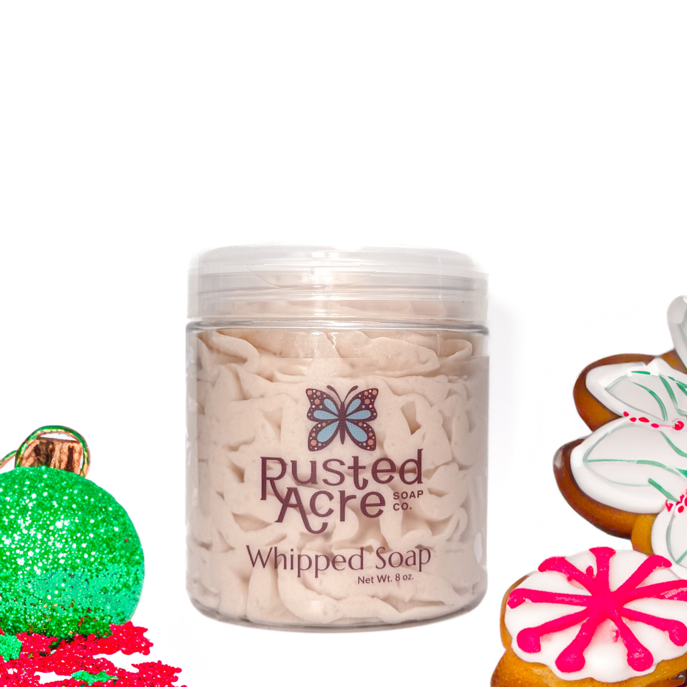Jar of Rusted Acre Soap Company's vegan sugar cookie whipped soap. Off White soap in a reusable plastic jar in a lifestyle setting.