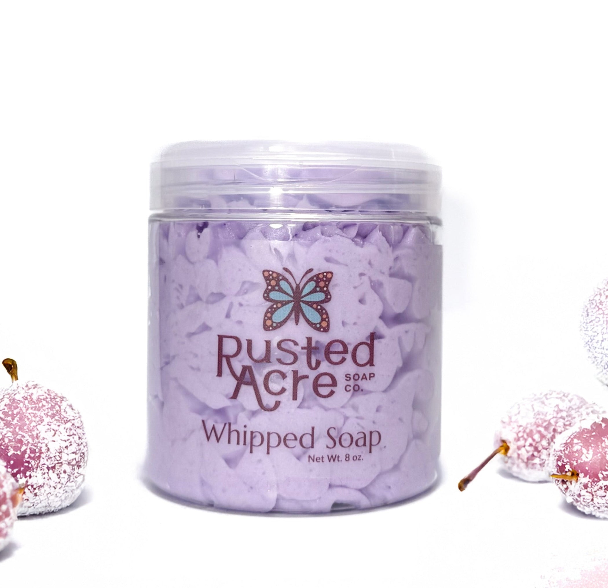 Jar of Rusted Acre Soap Company's vegan sugar plum whipped soap. Piurple soap in a reusable plastic jar in a lifestyle setting.