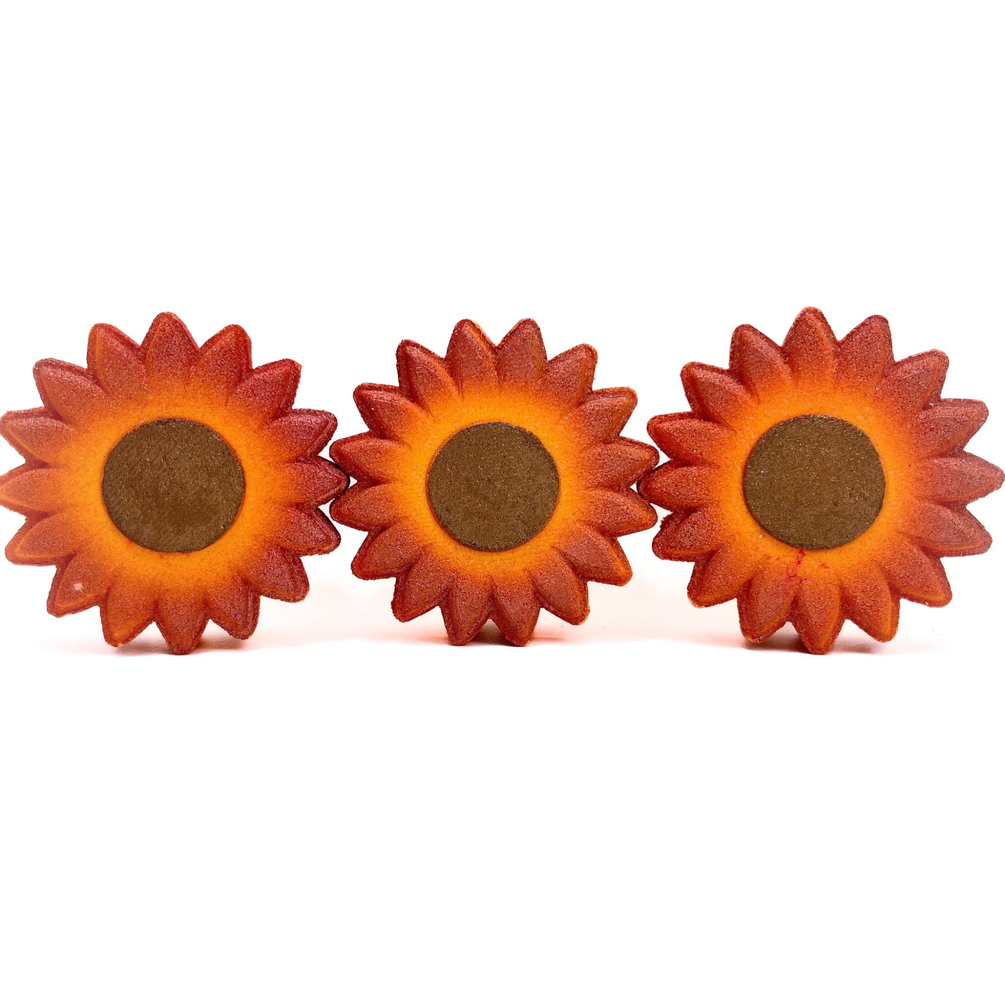 Three sunflower bath bombs. Each hand-painted brown center like seeds, yellow to orange gradient on the petals.