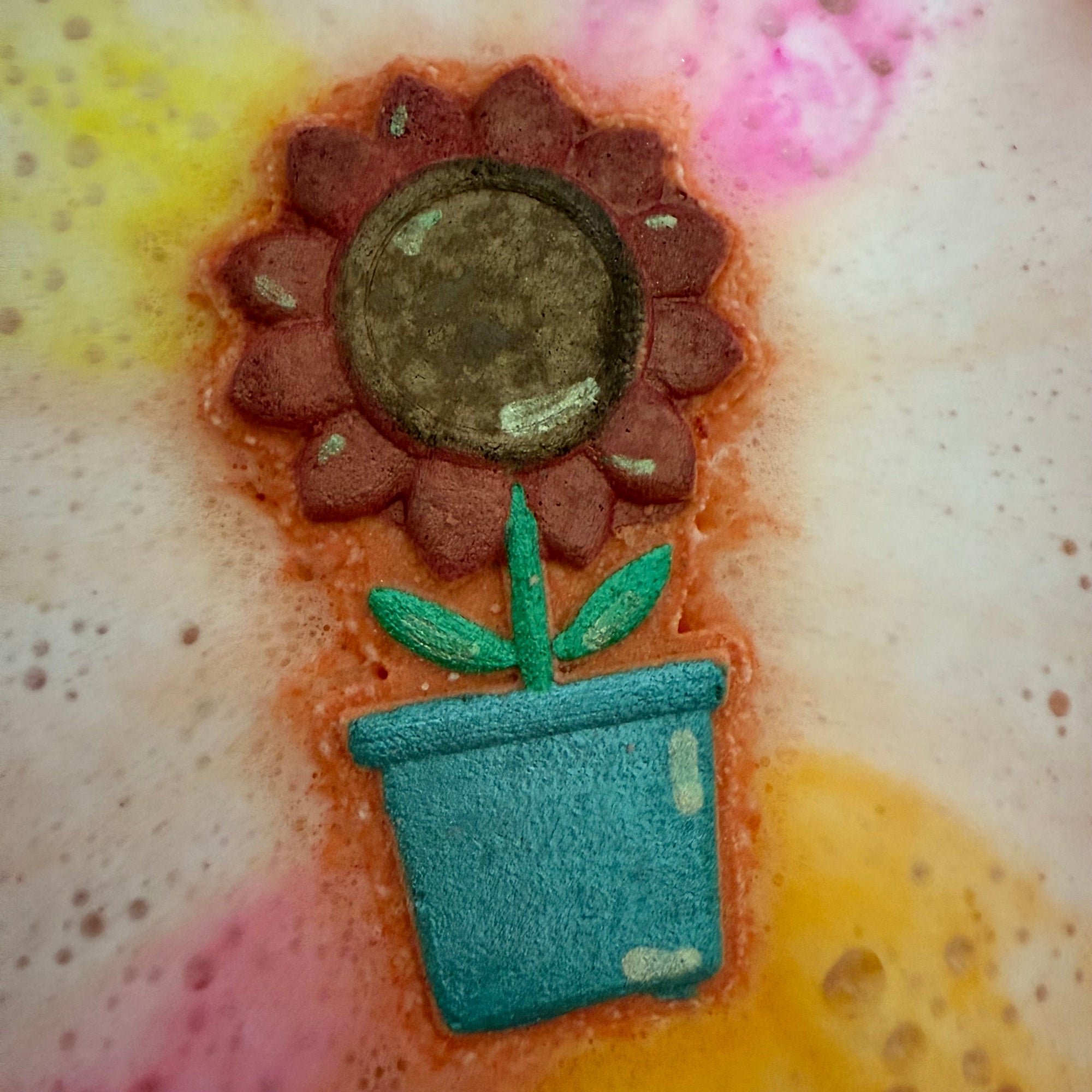 Rusted Acre Soap Companies Sunflower pot bath bomb. in the water putting on a color show.