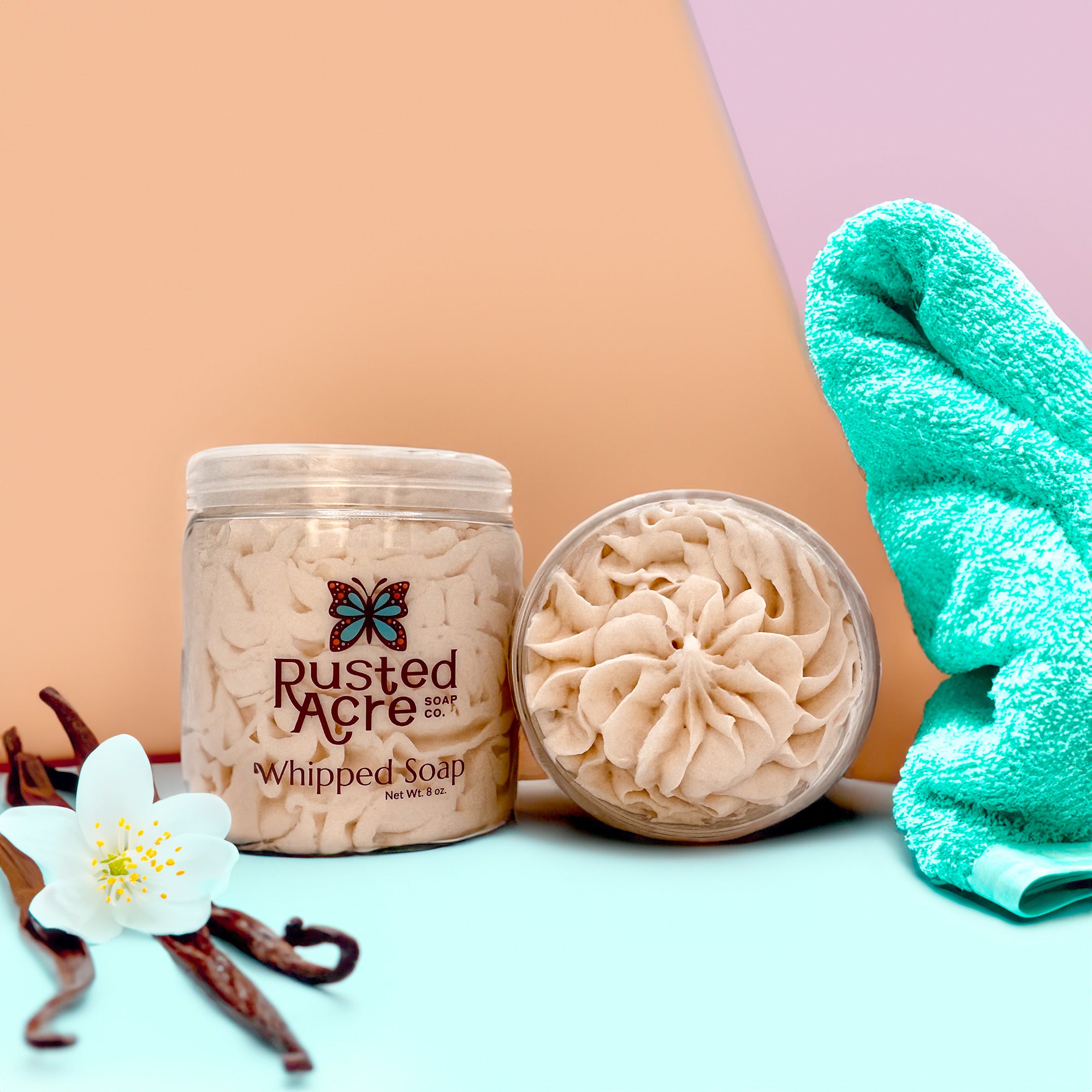 Two jars of Rusted Acre Soap Company’s vanilla bean whipped soap front and top view in a lifestyle setting.