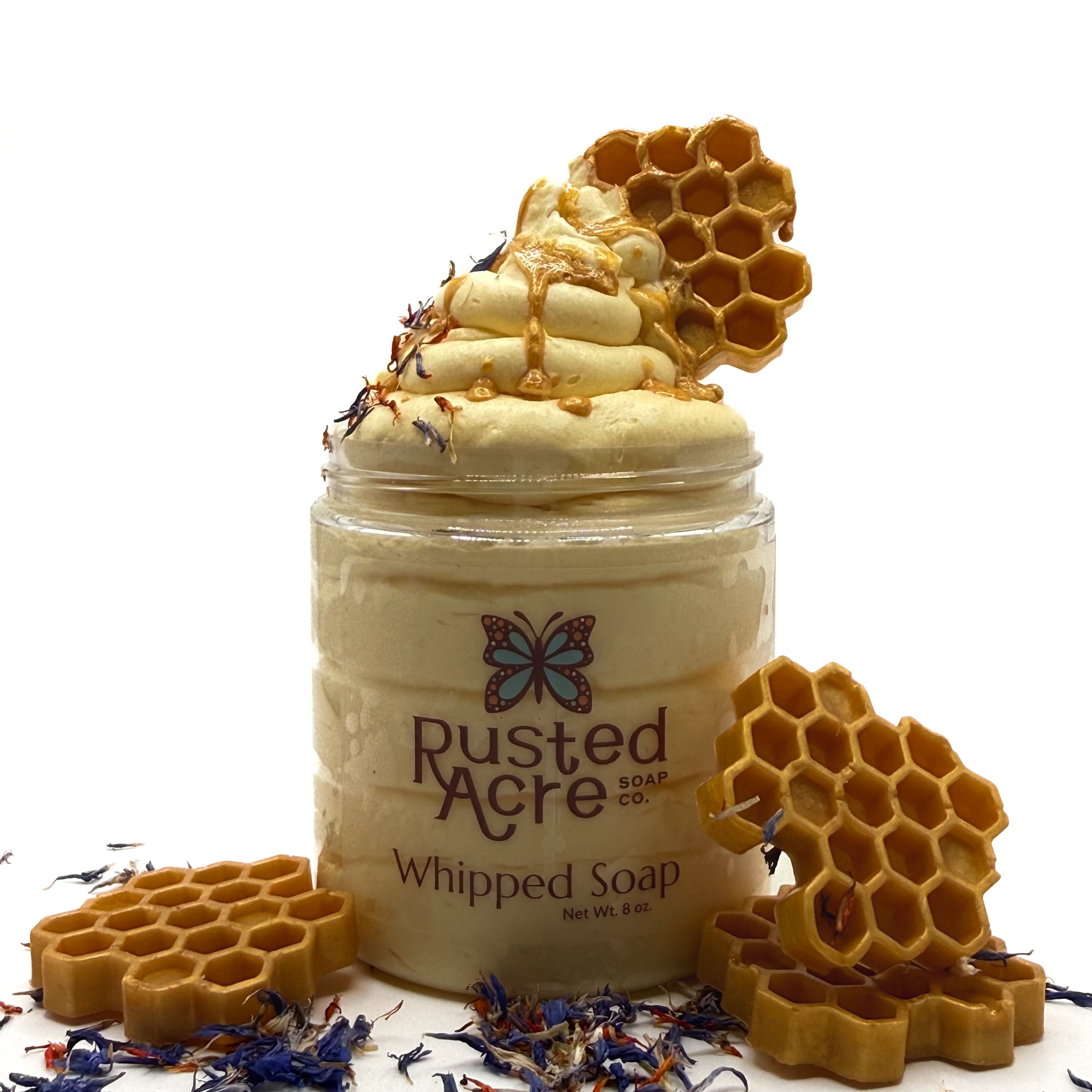 One jar of Rusted Acre whipped soap with honeycomb decorations on a white. background
