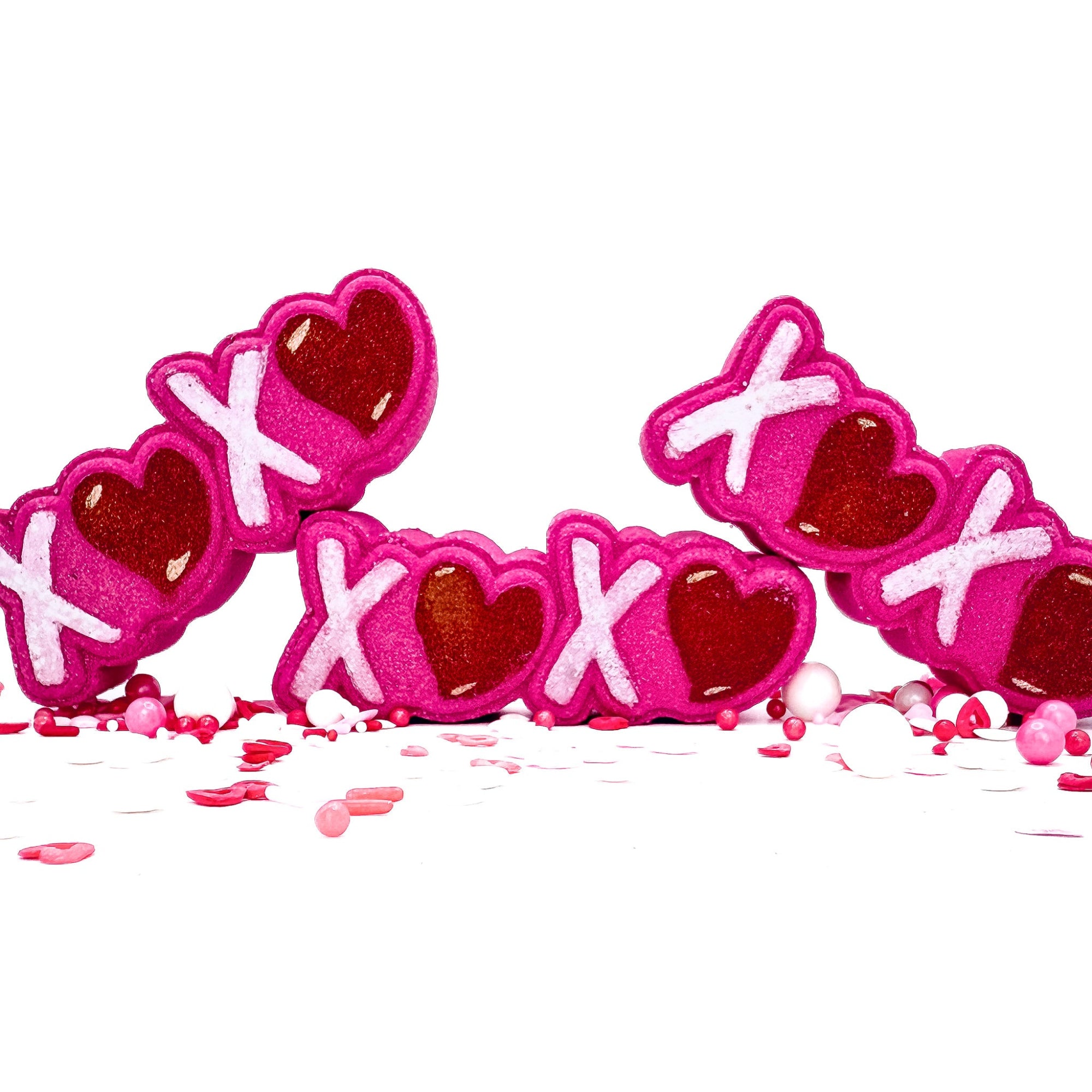 Three hand painted pink XOXO bath bombs from Rusted Acre Soap Company.