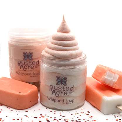 Two jars of Rusted Acre whipped soap with two ice cream bars of soap on a white background.
