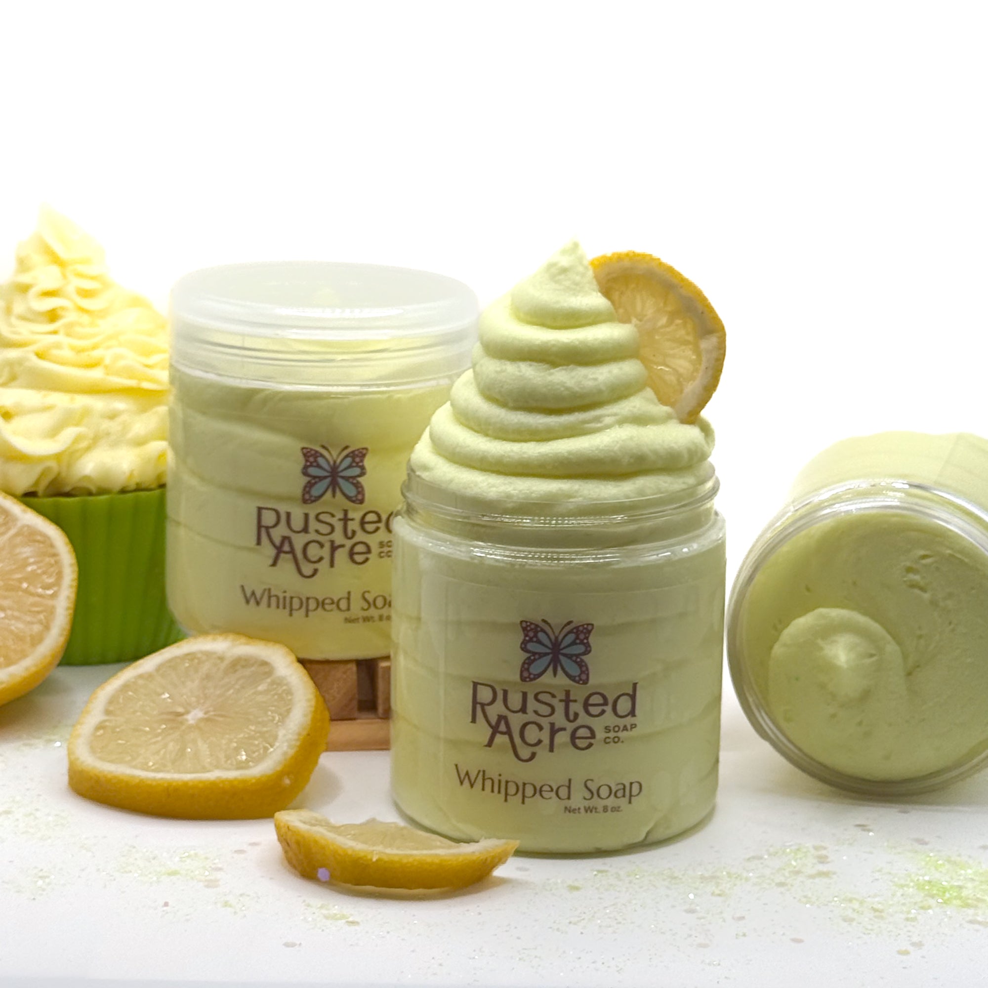 3 jars of Rusted Acre lemon cupcake whipped soap with lemon slices and cupcake on a white background.