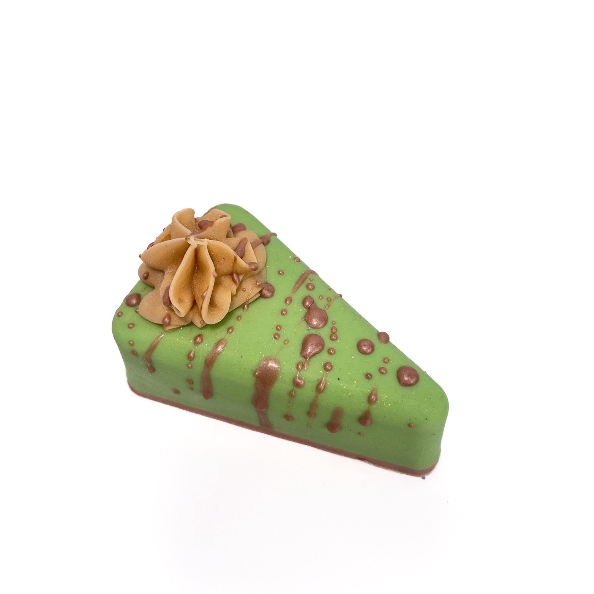 A top view of Rusted Acre Soap Company's handmade apple caramel pie soap. Green filling, tan soap drizzle, puff of cream colored soap.