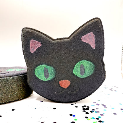 Rusted Acre Soap Co. Black Cat Bath Bomb with green eyes and pink ears, a Halloween-themed handmade gift for kids or cat lovers.