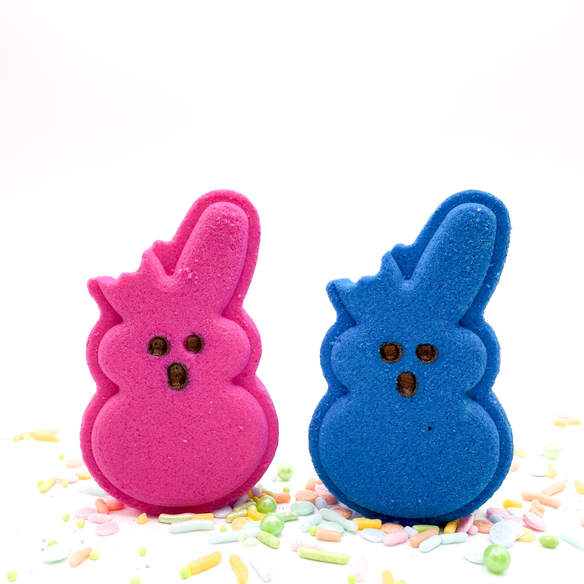One yellow and one pink handmade bitten bunny bath bombs from Rusted Acre Soap Co.
