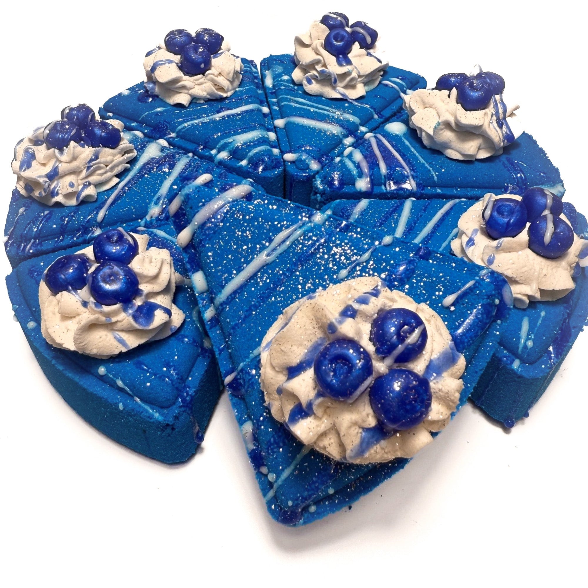 A pie of Rusted Acre Soap Company's blueberry pie bath bombs topped with soap blueberries and bubble bath frosting. 